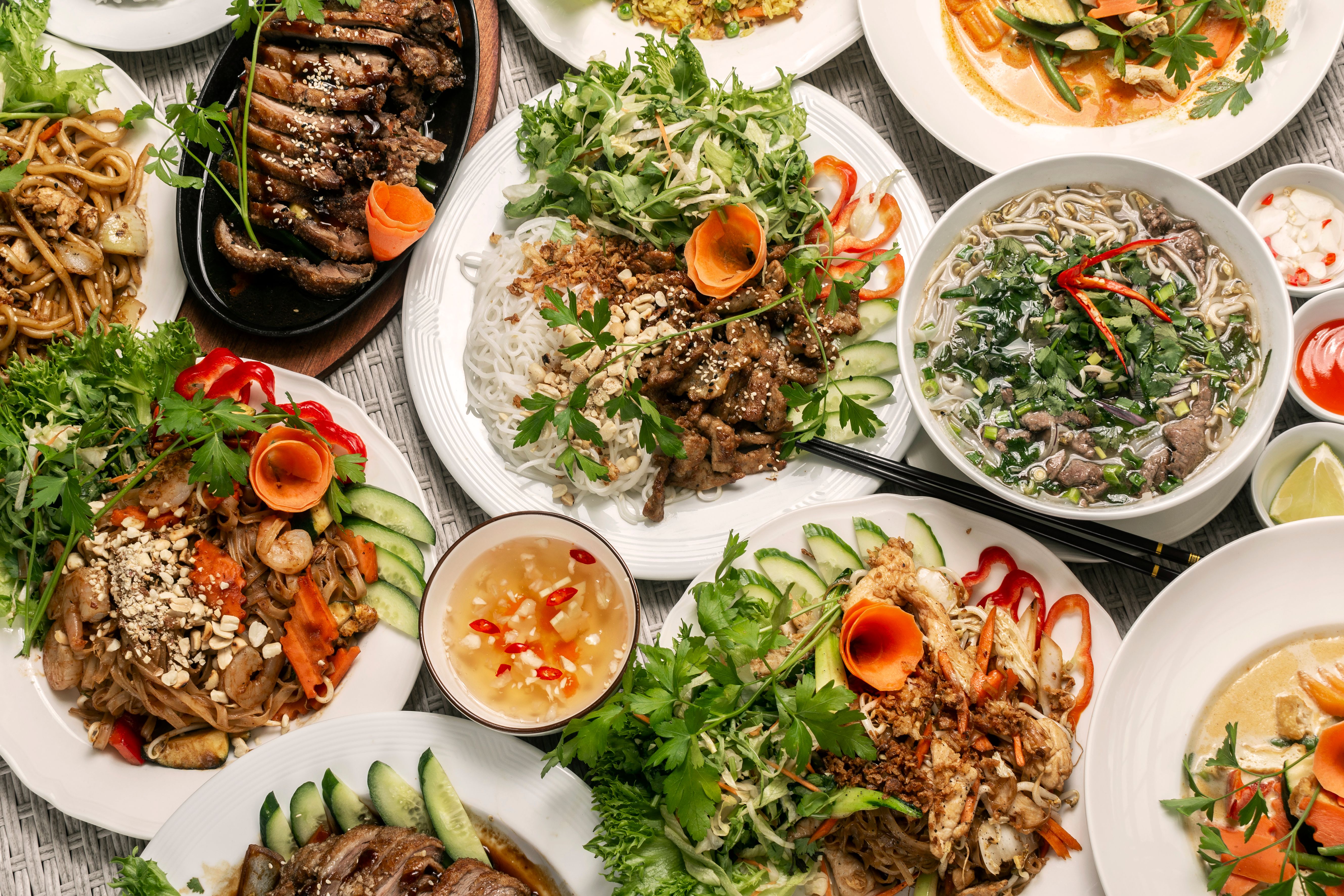 assortment of mixed traditional vietnamese food dishes on buffet table