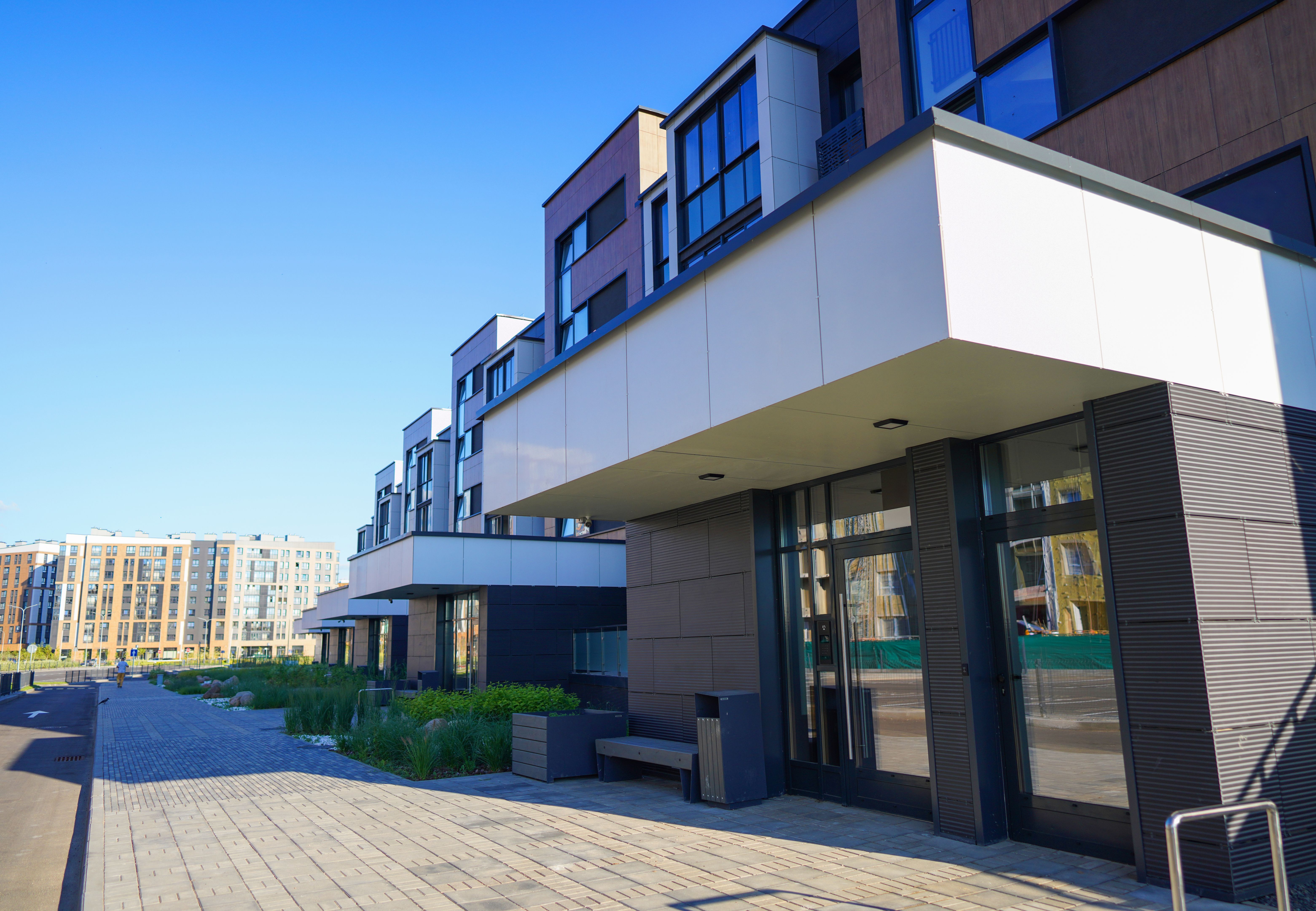 Modern complex building. Street with road and sidewalk.