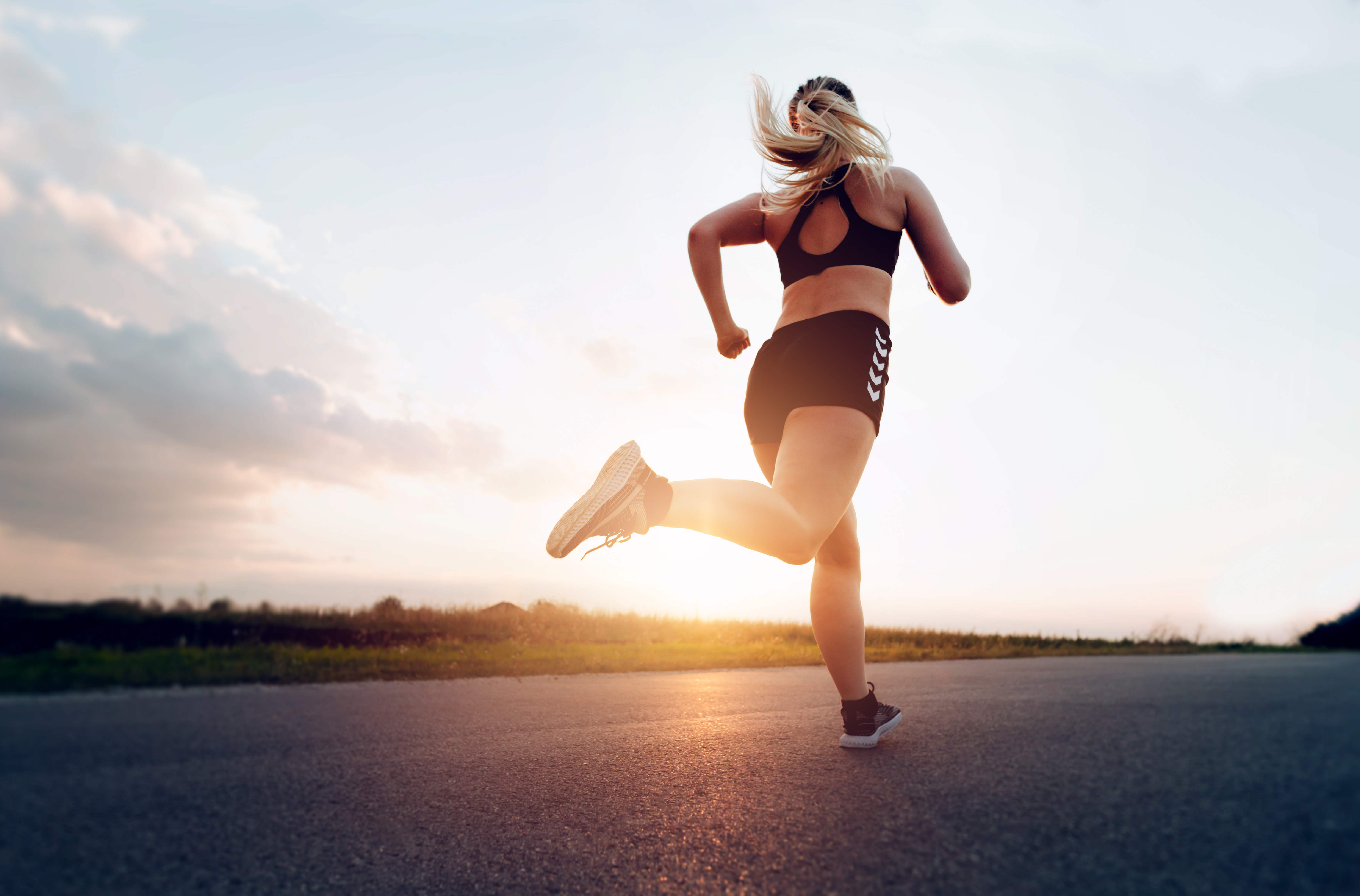 Sporty woman running at sunset on the road.Concept of health, slimming and maintaining youth