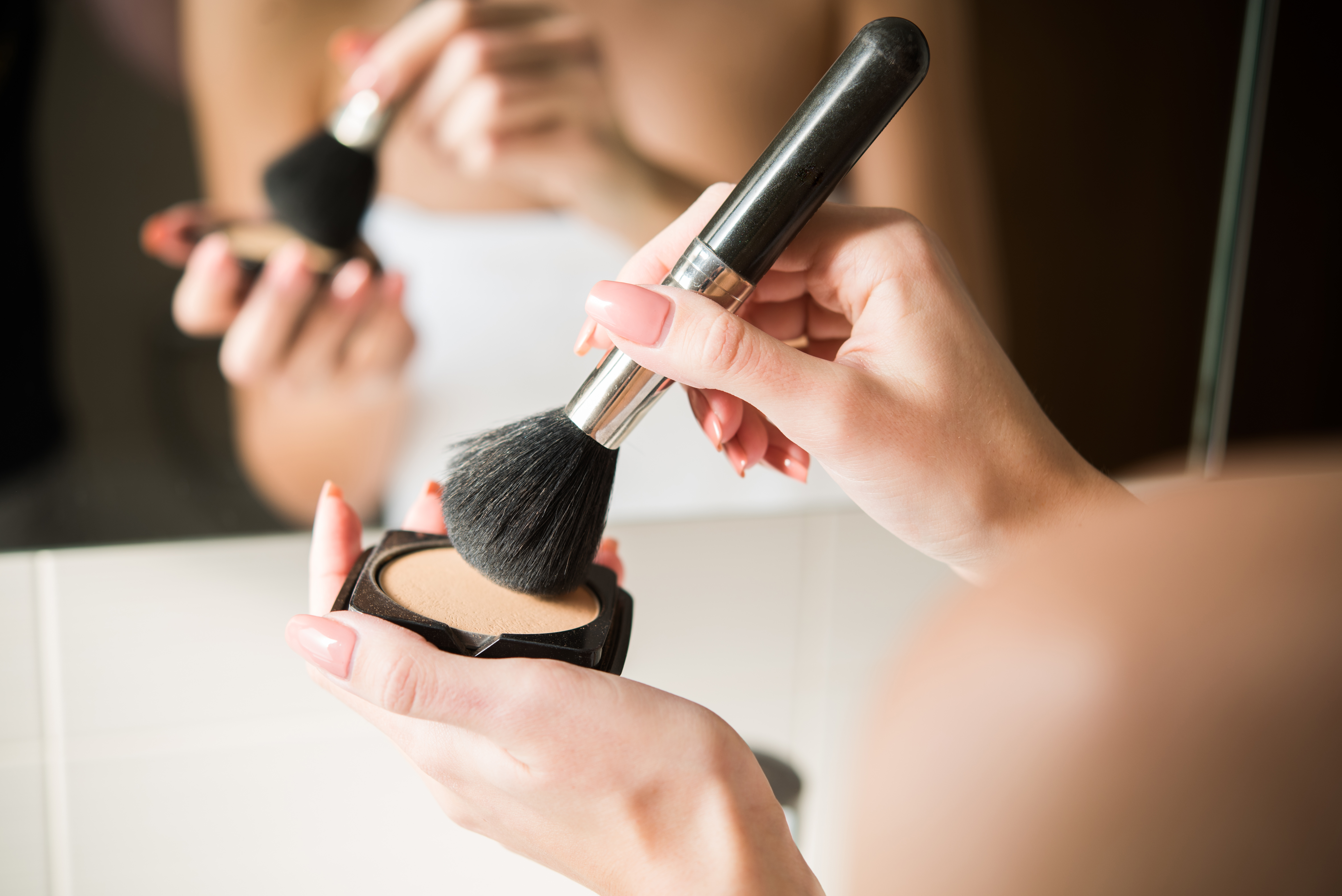 Close-up shot of a woman putting powder on a make-up brush