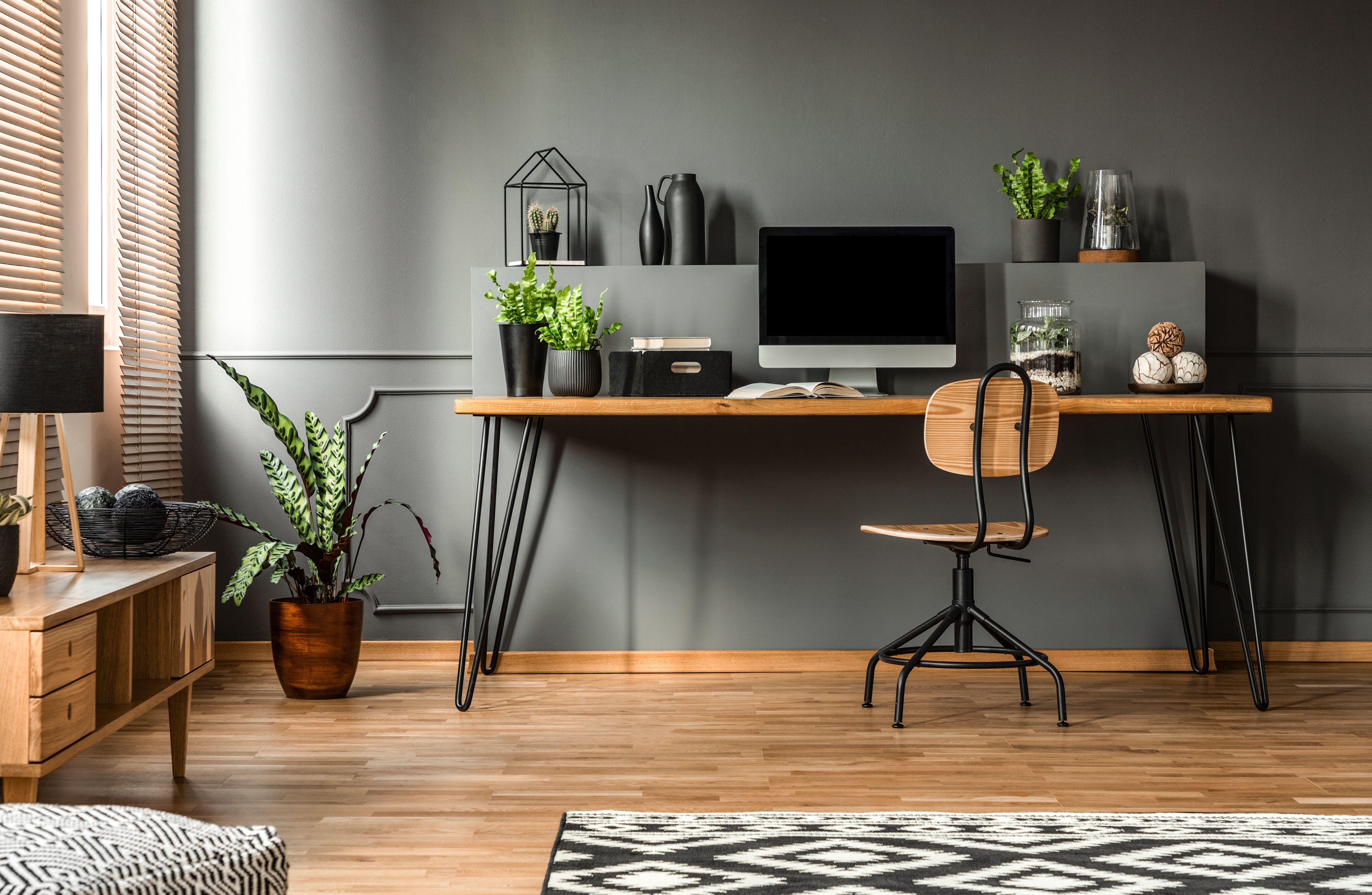 Real photo of a dark interior with wooden desk, chair and computer in the study space in the middle Real photo of a dark interior with wooden desk, chair and computer in the study space in the middle