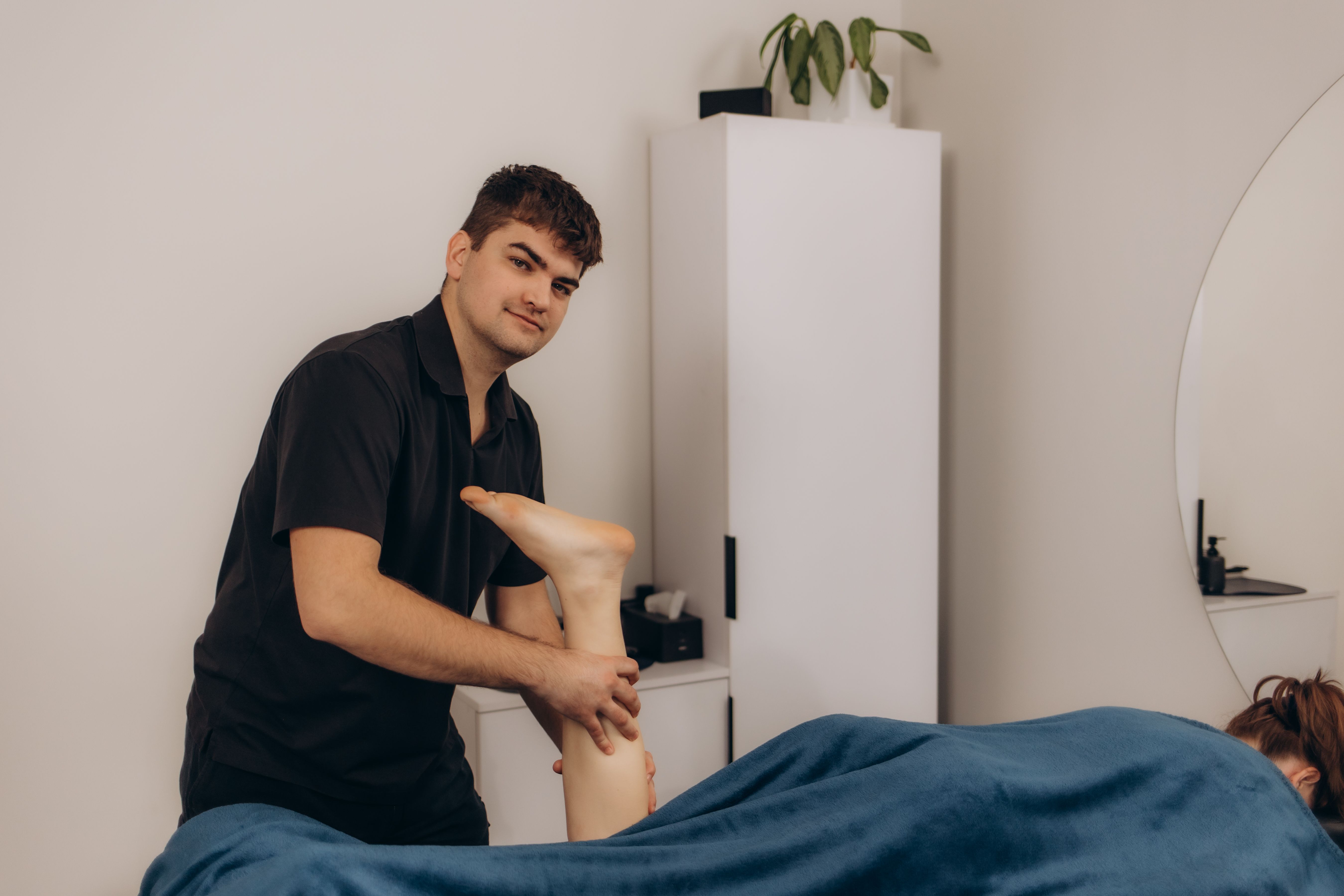 Closeup of a man giving a relaxing foot massage to a man at a peaceful spa, promoting well-being and serenity. The session emphasizes beauty and wellness in a serene indoor environment