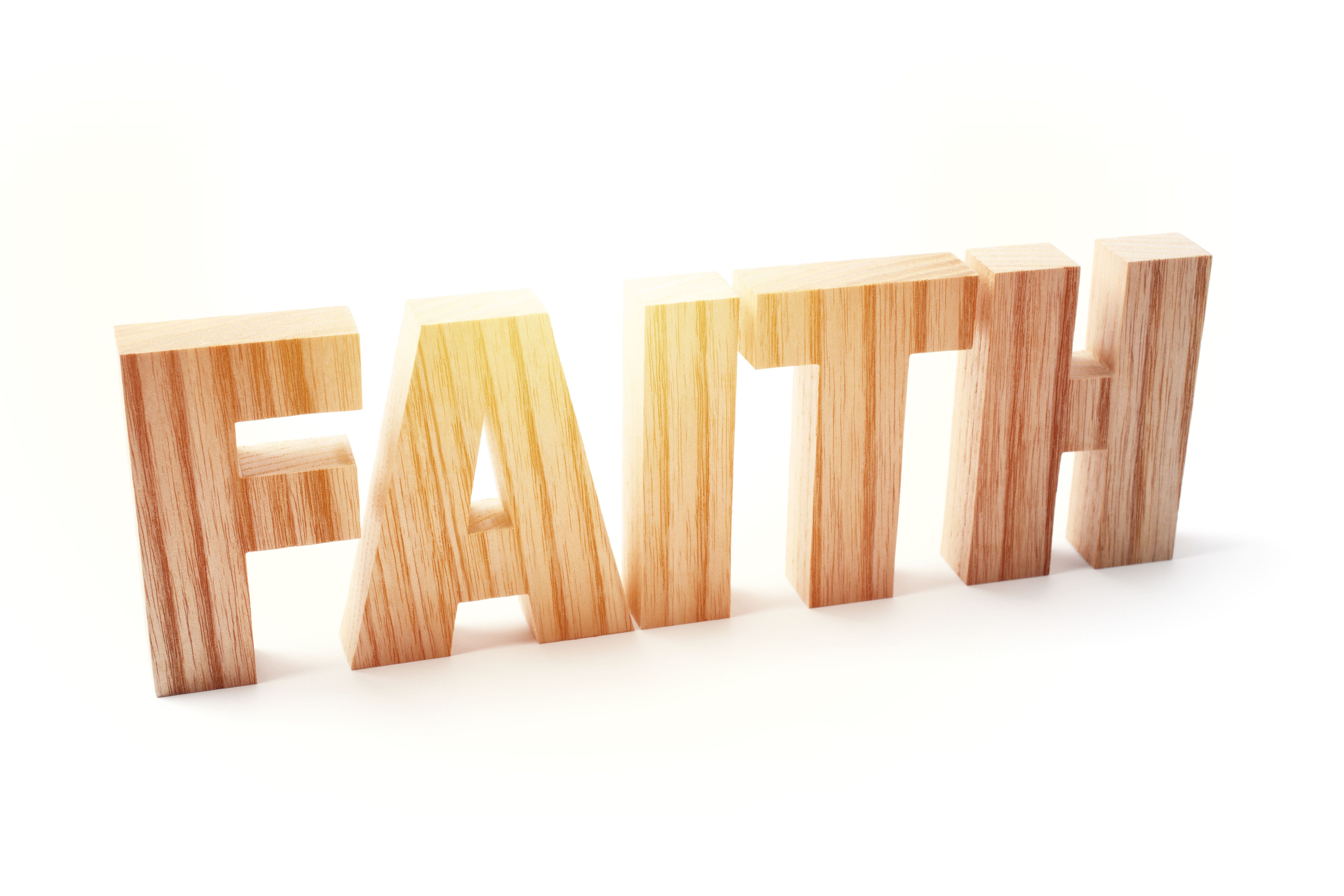 Close-up of Wooden Letters Sign Says FAITH on White Background