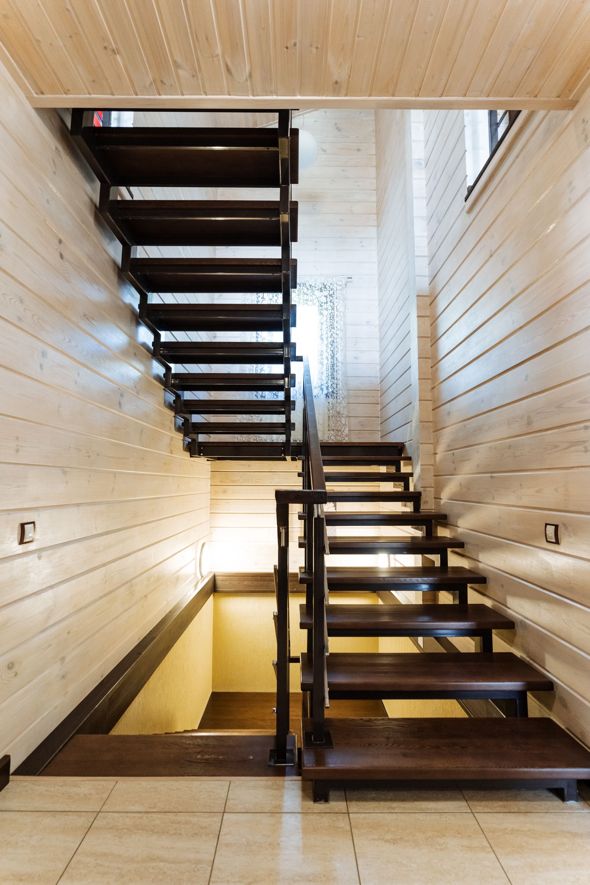 A beautifully crafted wooden staircase gracefully leading up to the second floor of a charming wooden house, adding character and elegance to the overall design of the home A beautifully crafted wooden staircase gracefully leading up to the second floor of a charming wooden house, adding character and elegance to the overall design of the home