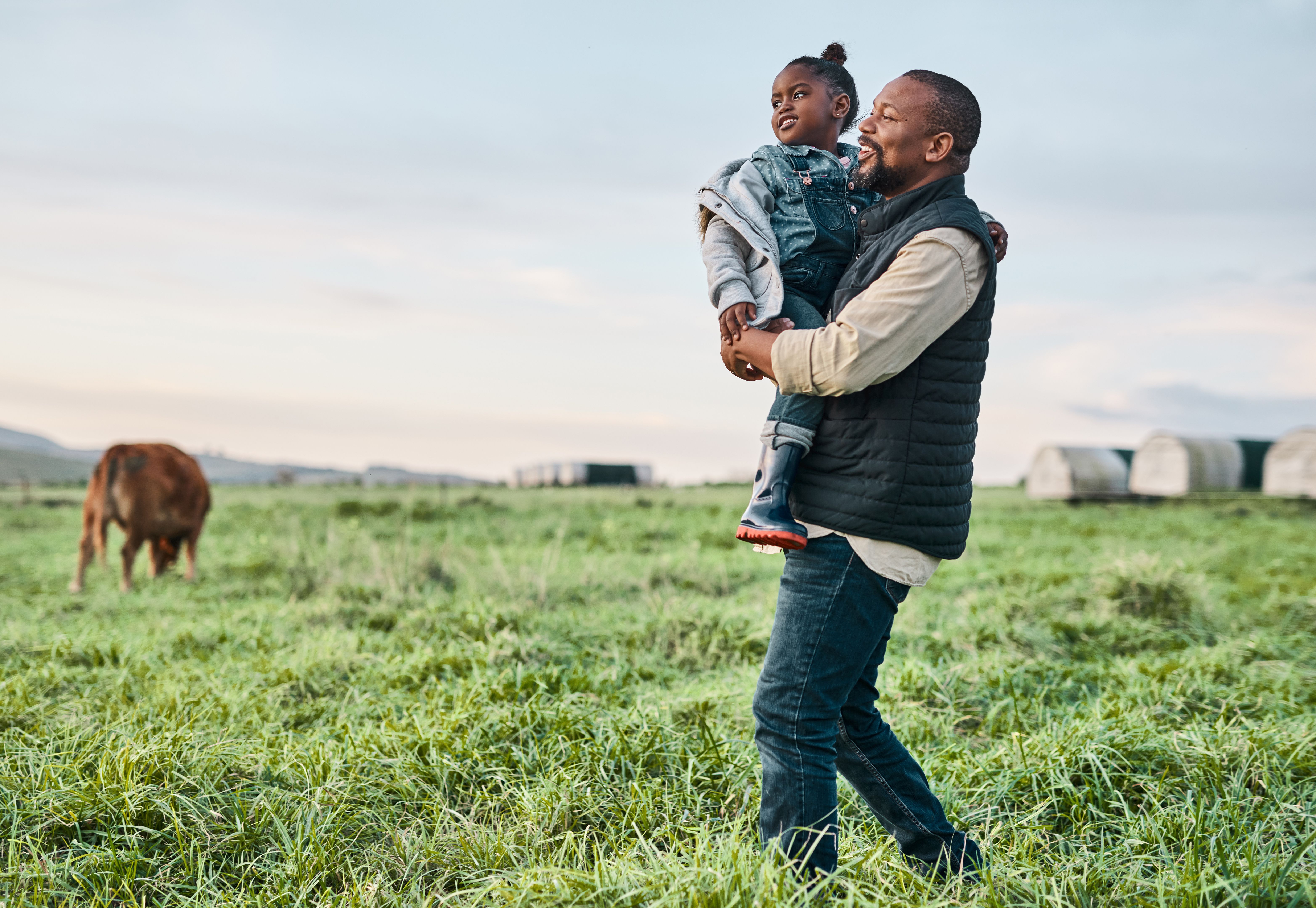 eco-friendly living, father with kid in his hands in a farm