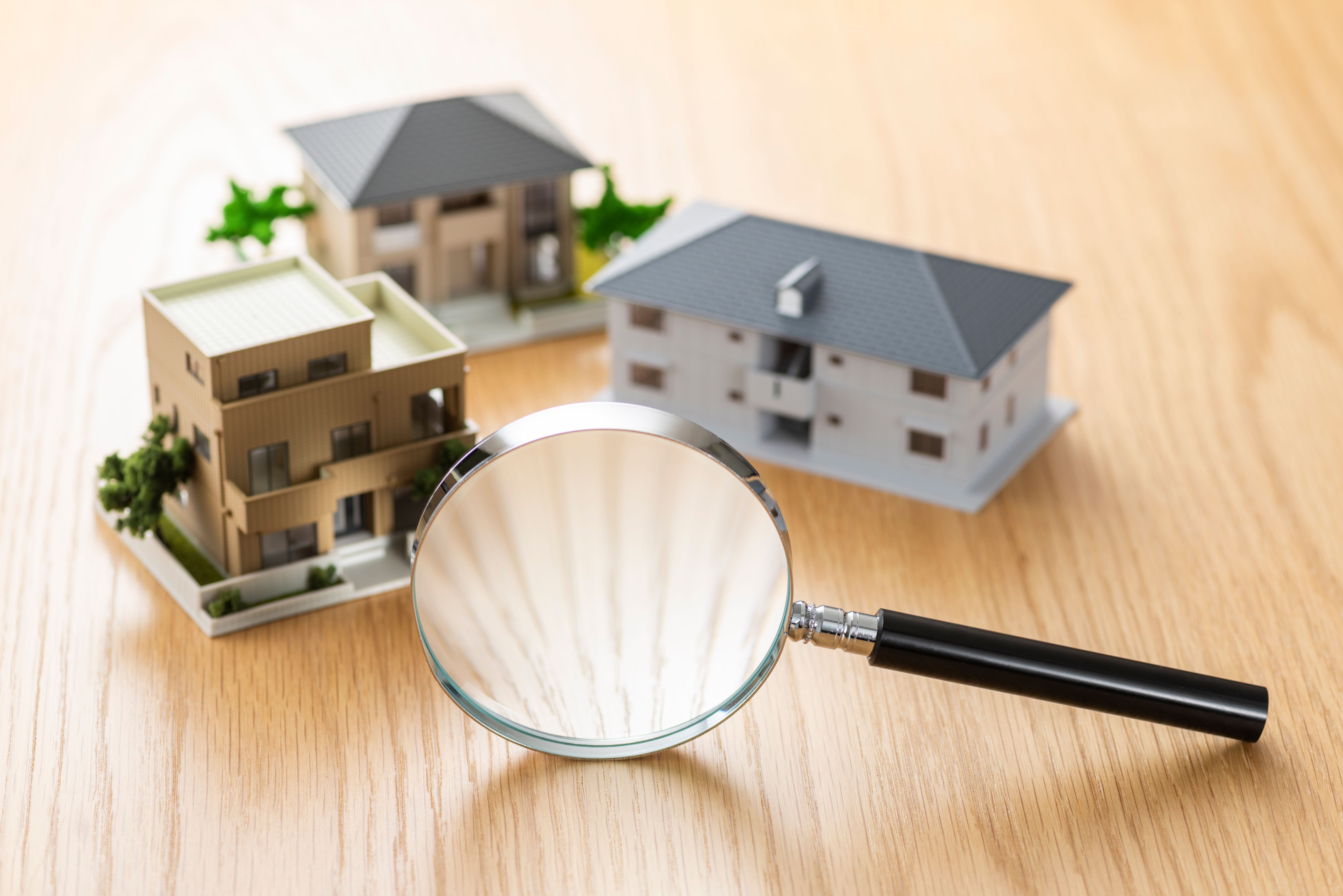 House model and loupe on wooden table