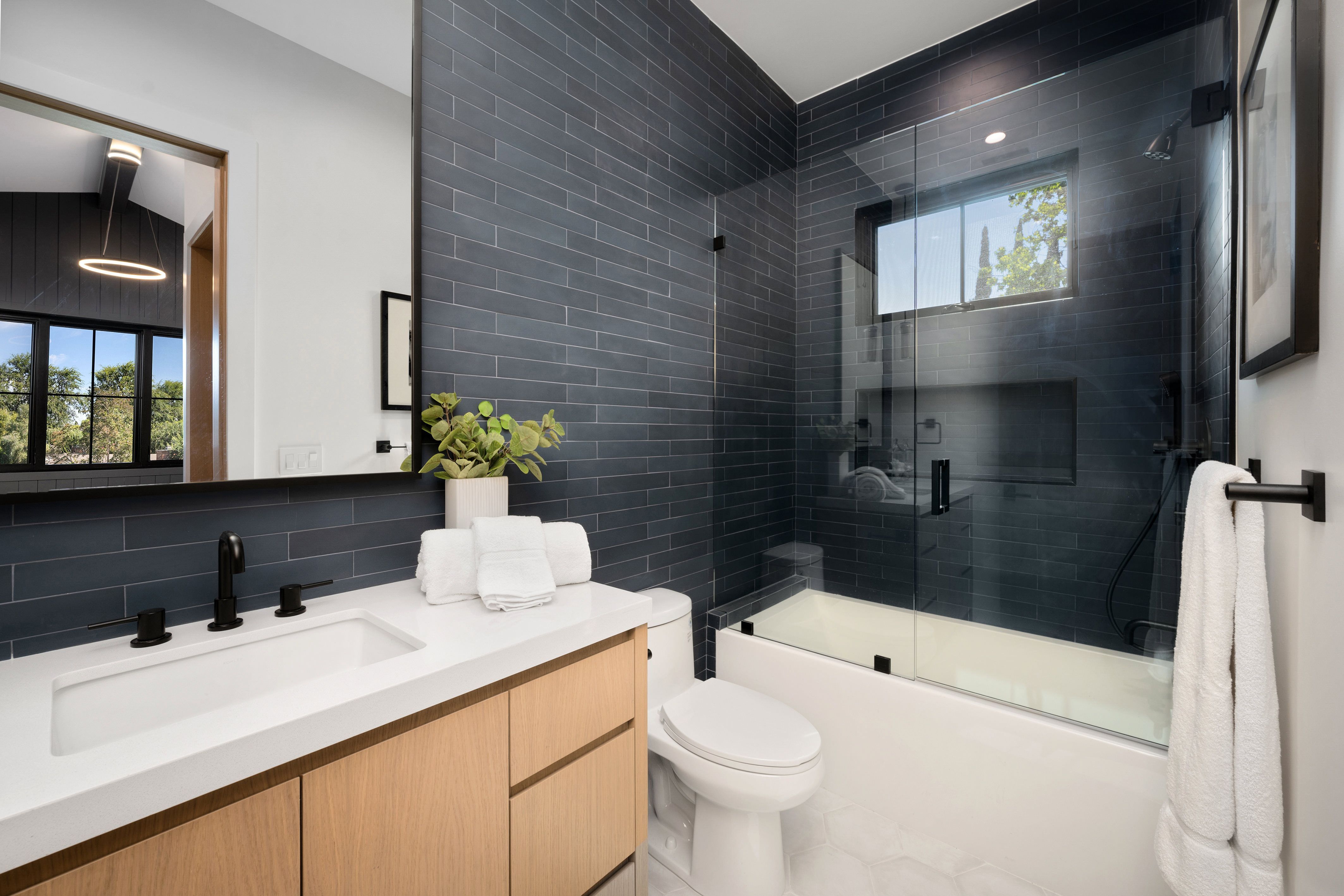 Modern bathroom with glass shower and white vanity.