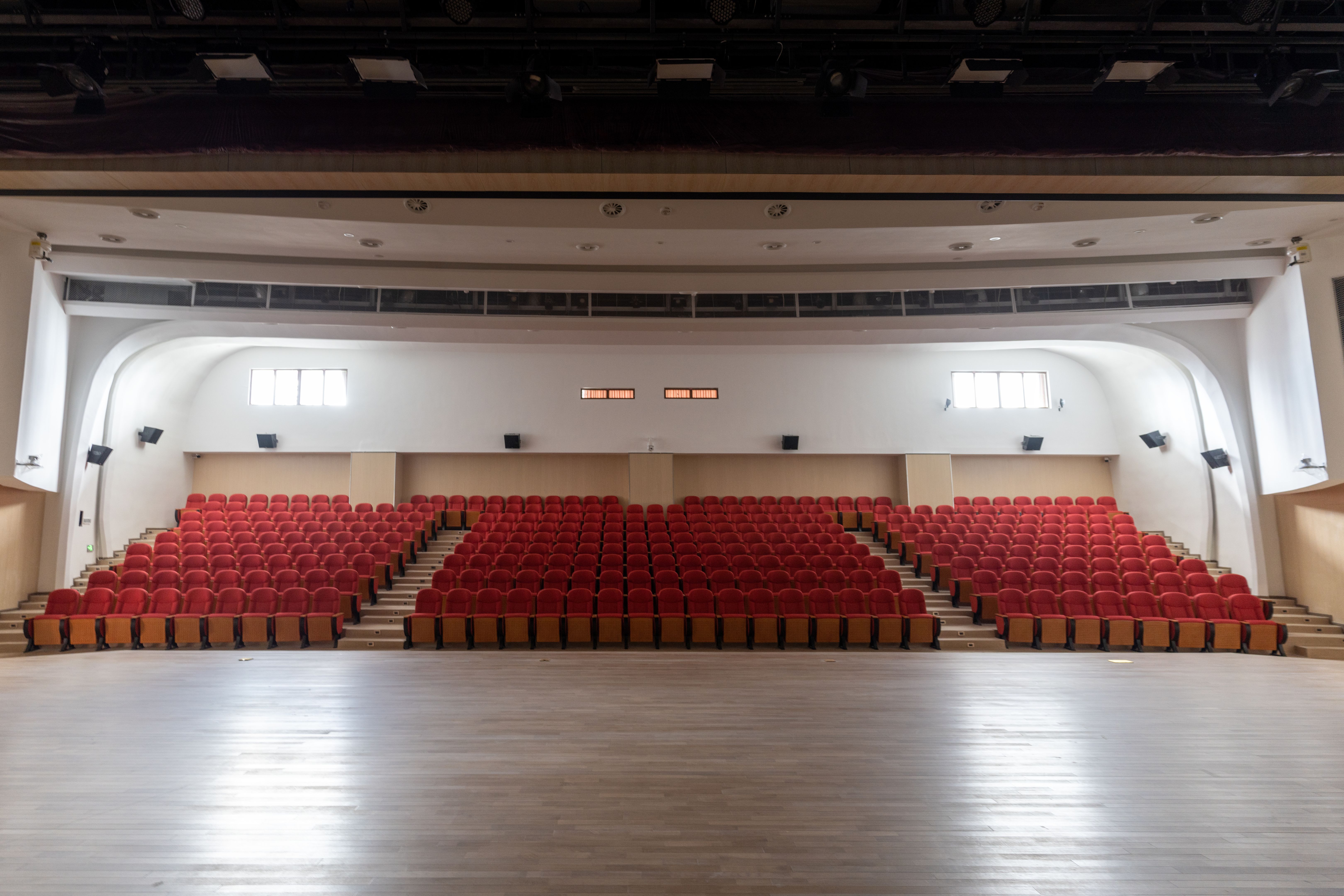 A row of neat red chairs in the unfinished theater