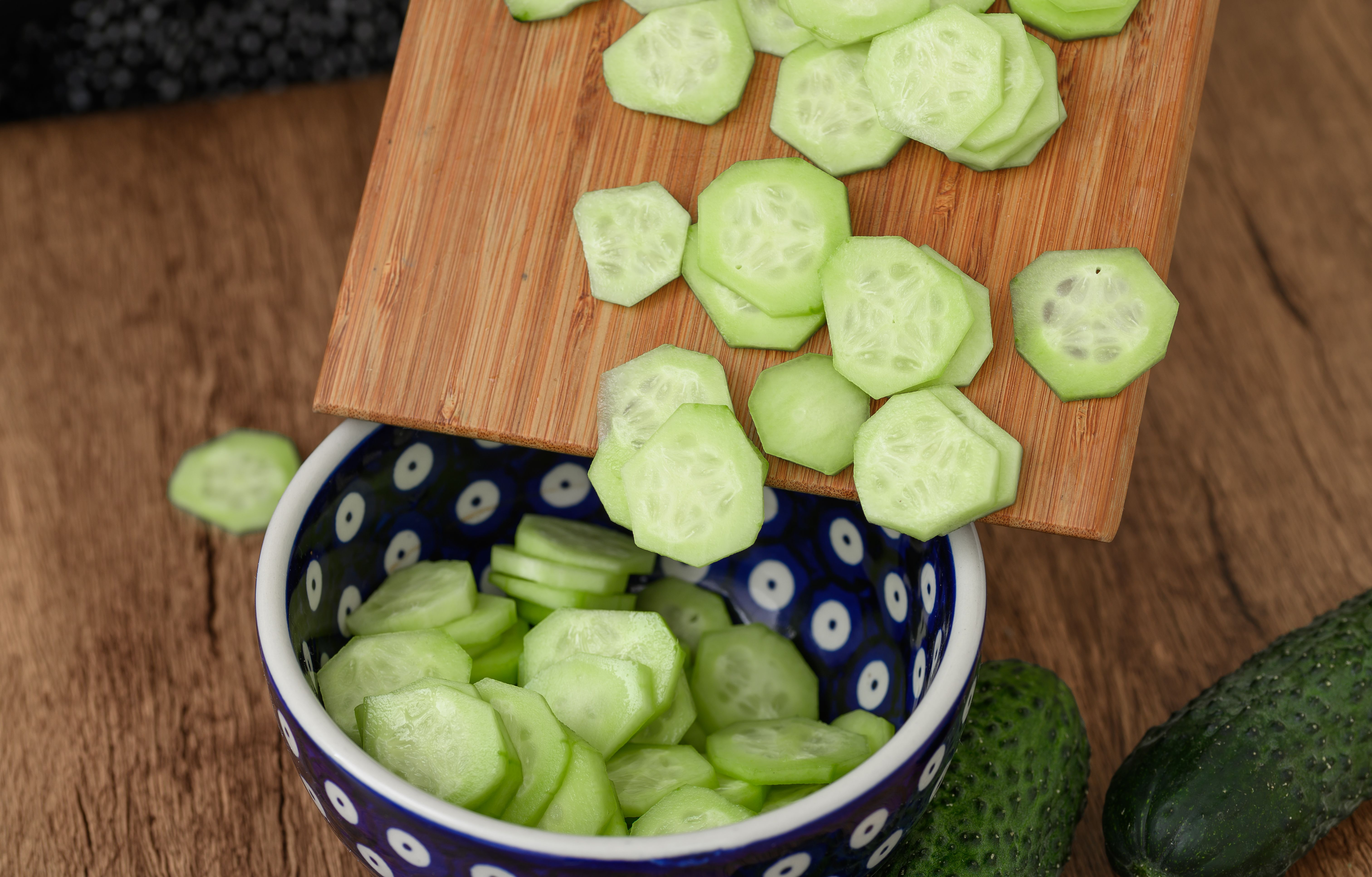 cook cutting fresh cucumber into slices, Polish cuisine