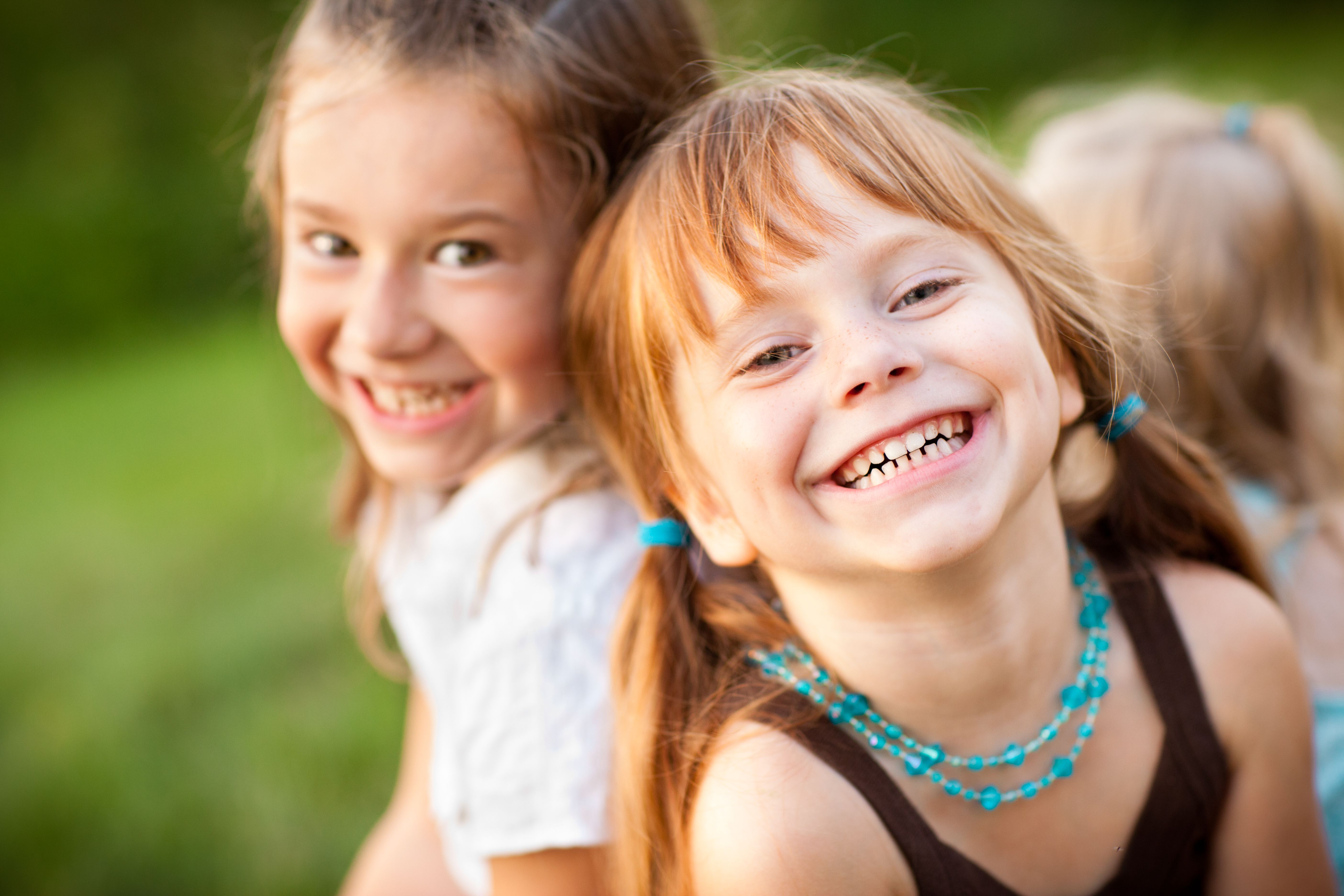 Three Happy Sisters Laughing While Sitting Together Outside Three Happy Sisters Laughing While Sitting Together Outside