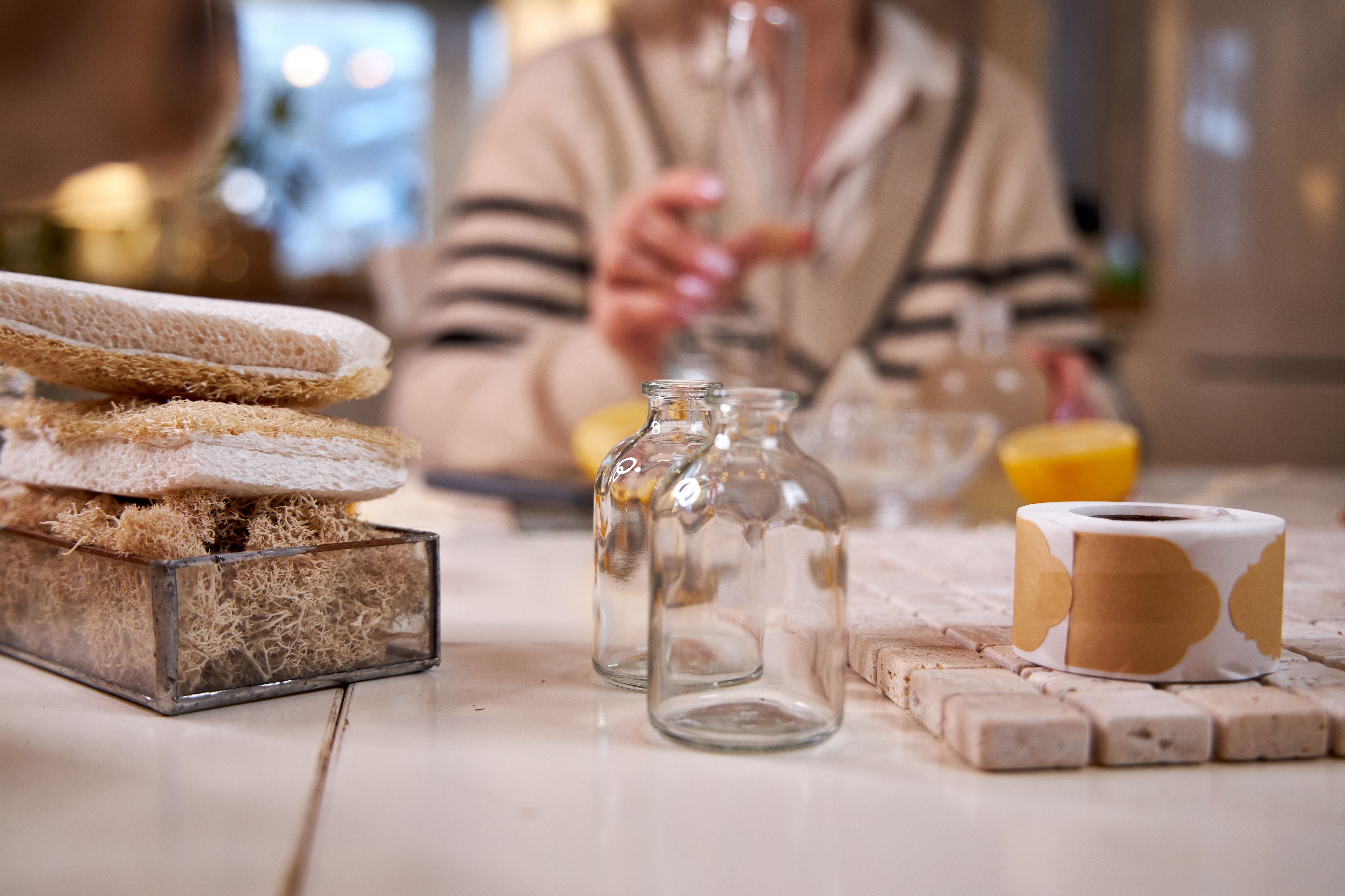 Mature woman making her own natural non toxic cleaning products at home with white vinegar and fresh lemon