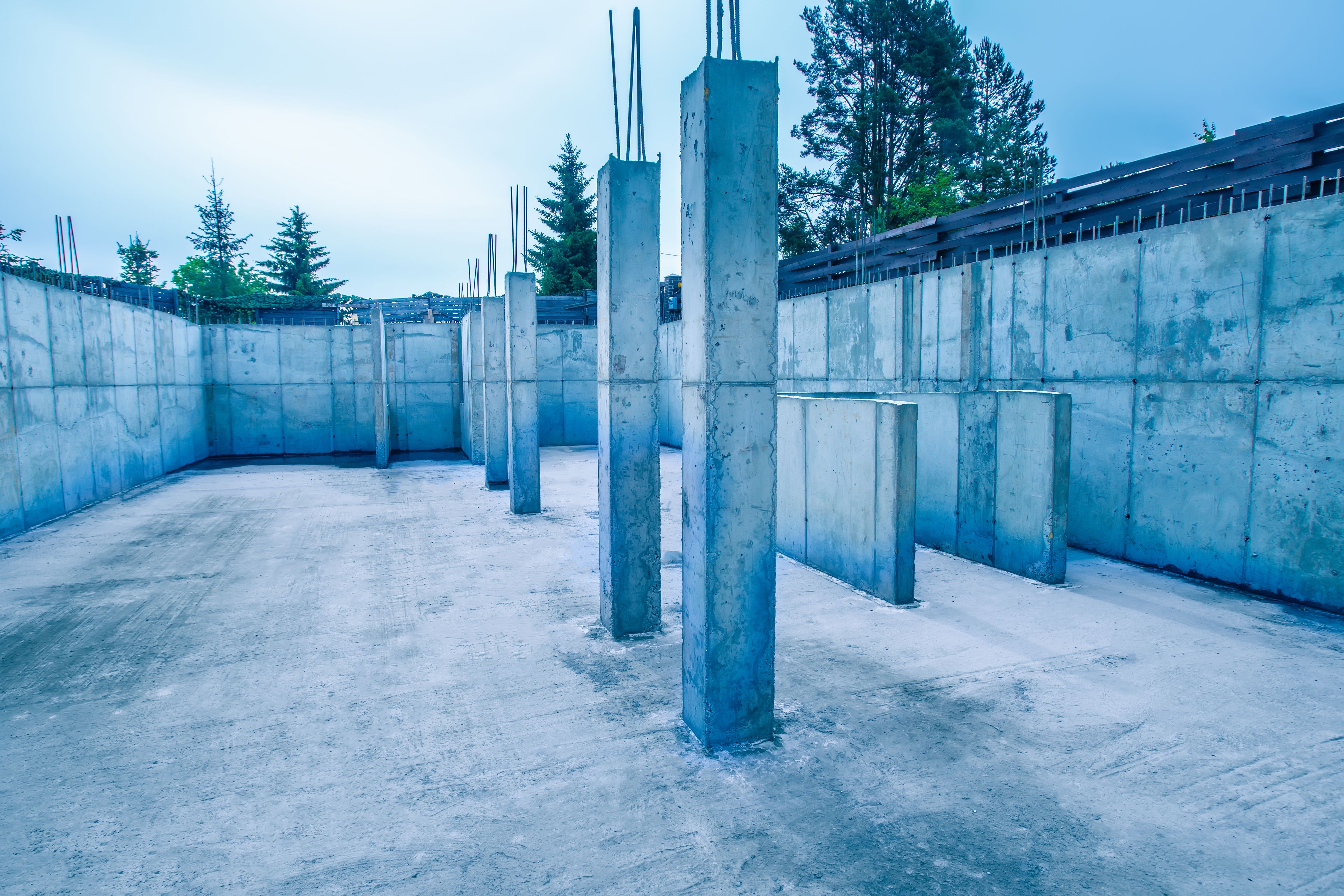 Construction of concrete. Columns made of concrete. The foundation of a building with columns. The armature sticks out of the columns of the building. Construction site of concrete. Construction of concrete. Columns made of concrete. The foundation of a building with columns. The armature sticks out of the columns of the building. Construction site of concrete.