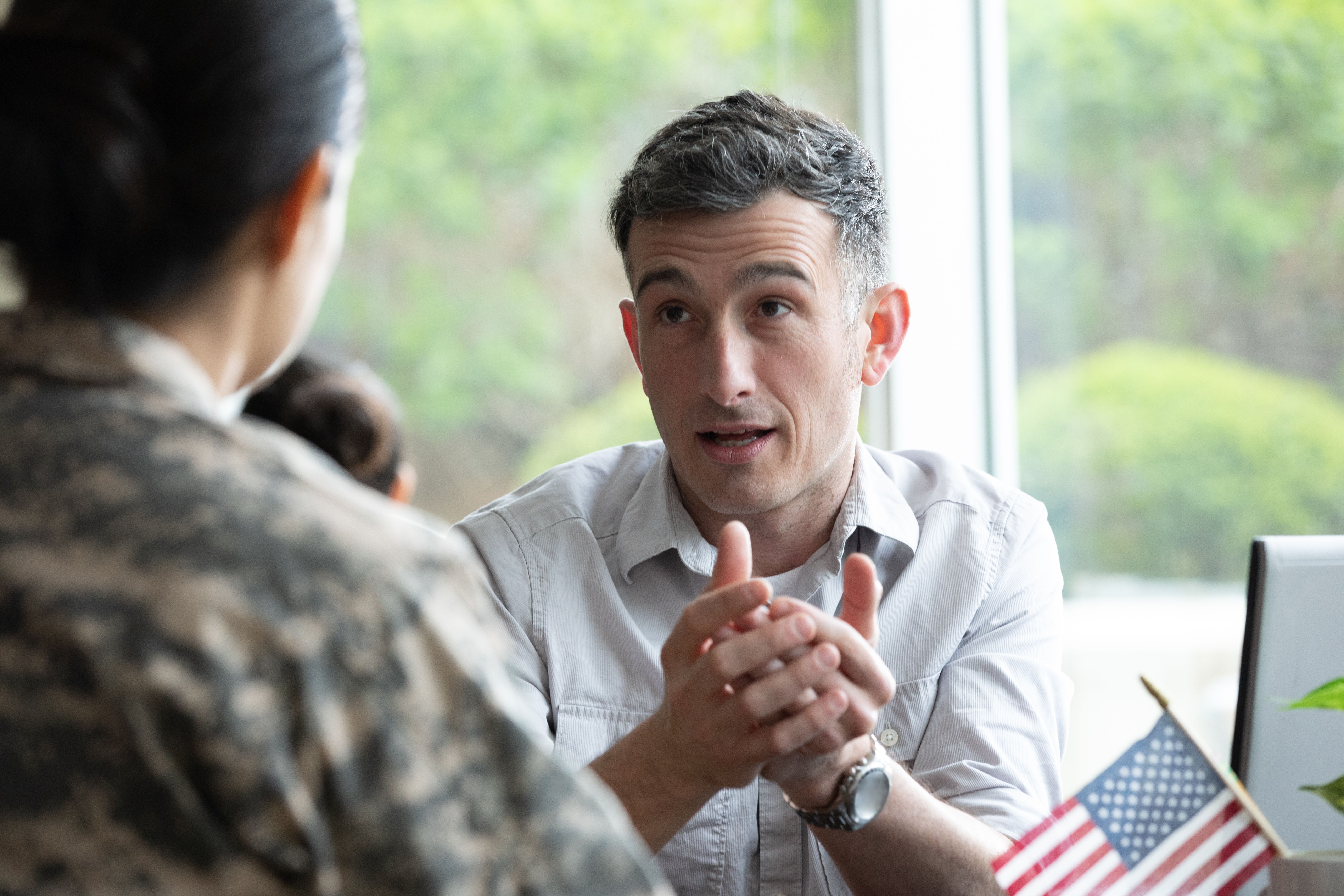 Mature financial planner meeting with a military solider.