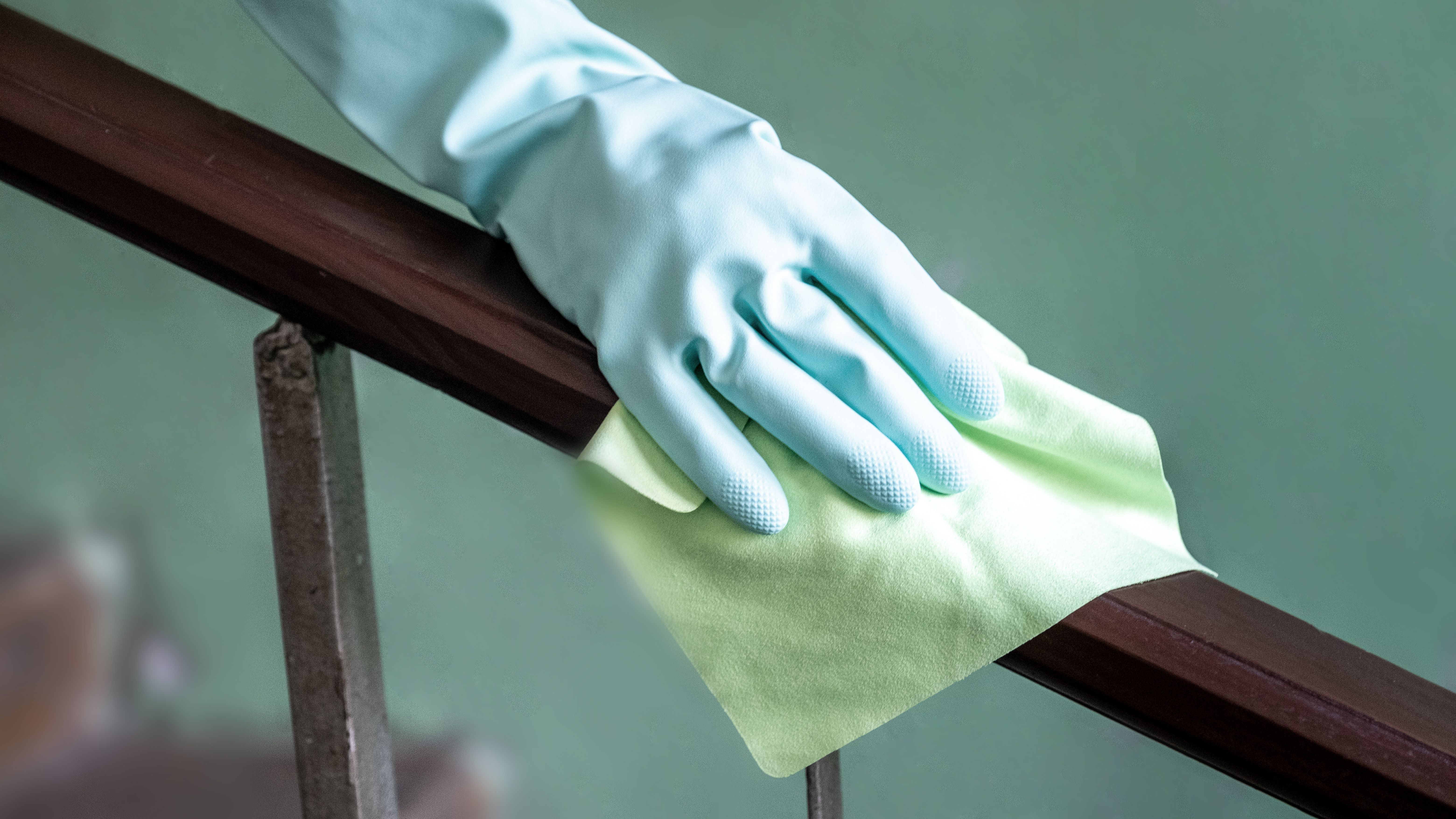 Closeup view of a woman's hand using an antibacterial wet wipe for disinfecting the railing on the flying cage. Closeup view of a woman's hand using an antibacterial wet wipe for disinfecting the railing on the flying cage.