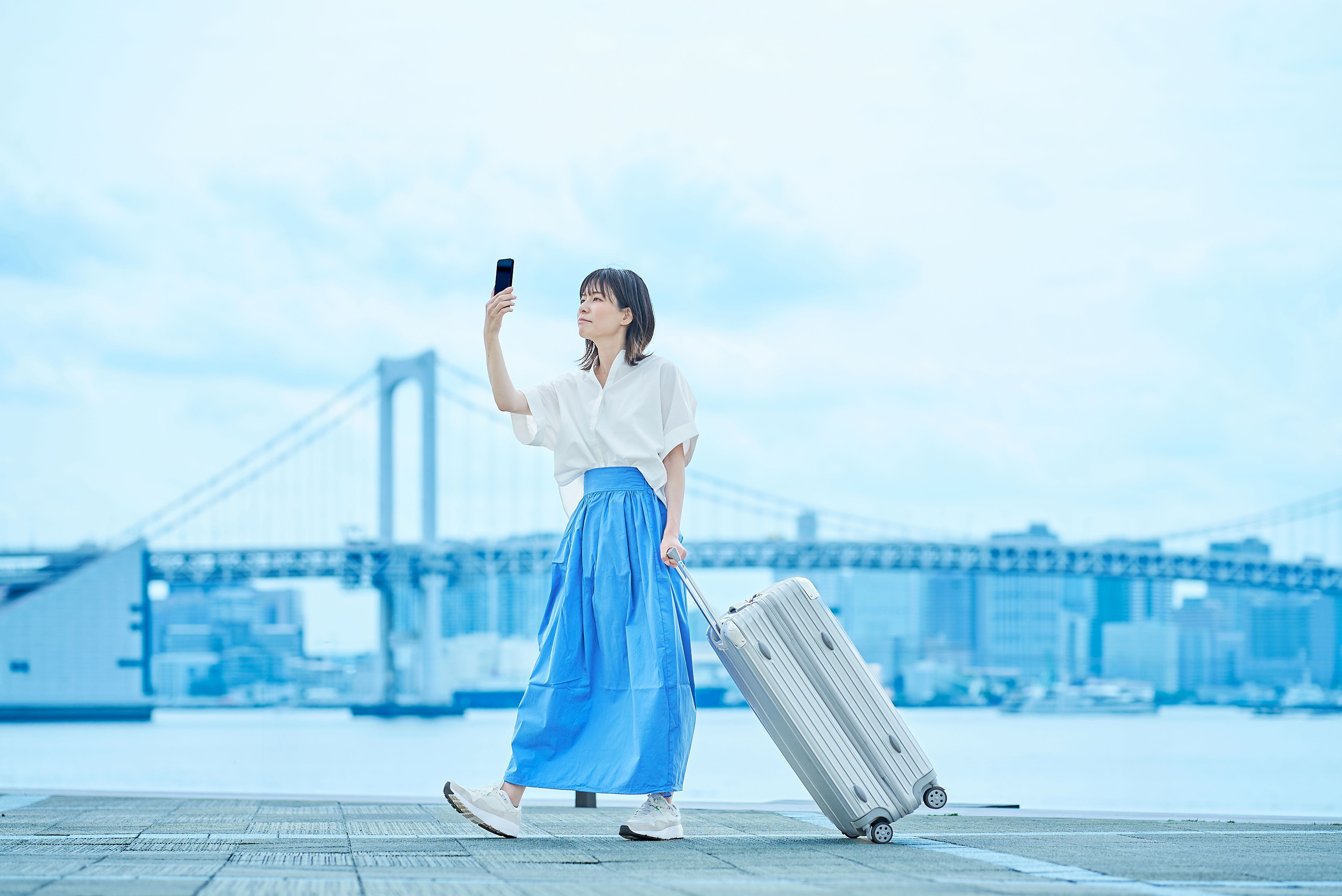 Young woman walking with suitcase