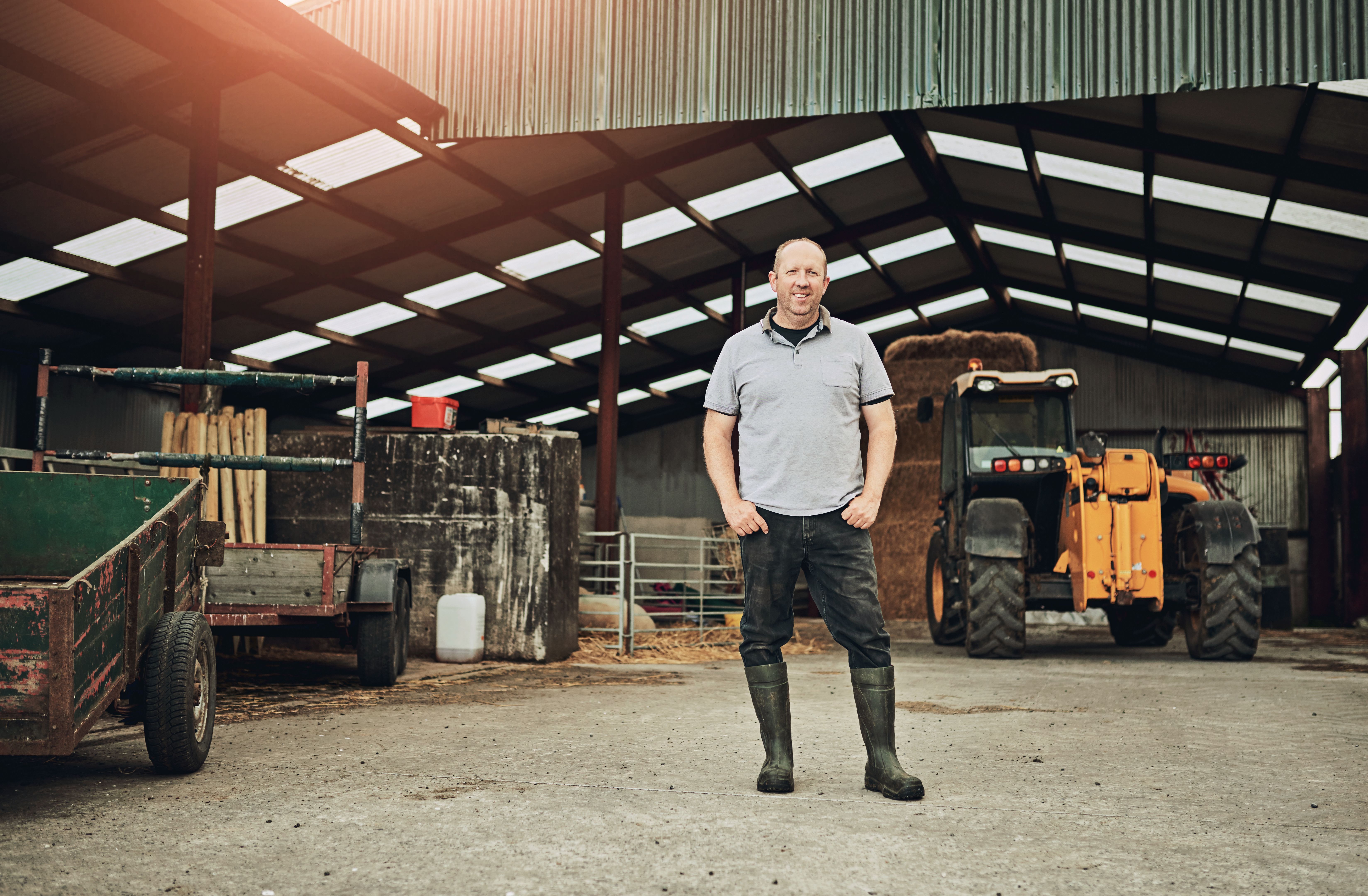 Farm, tractor and portrait of man in barn with equipment for farming, harvest and production. Agriculture, countryside and farmer with machine in shed, factory and storage with plow truck for fields Farm, tractor and portrait of man in barn with equipment for farming, harvest and production. Agriculture, countryside and farmer with machine in shed, factory and storage with plow truck for fields