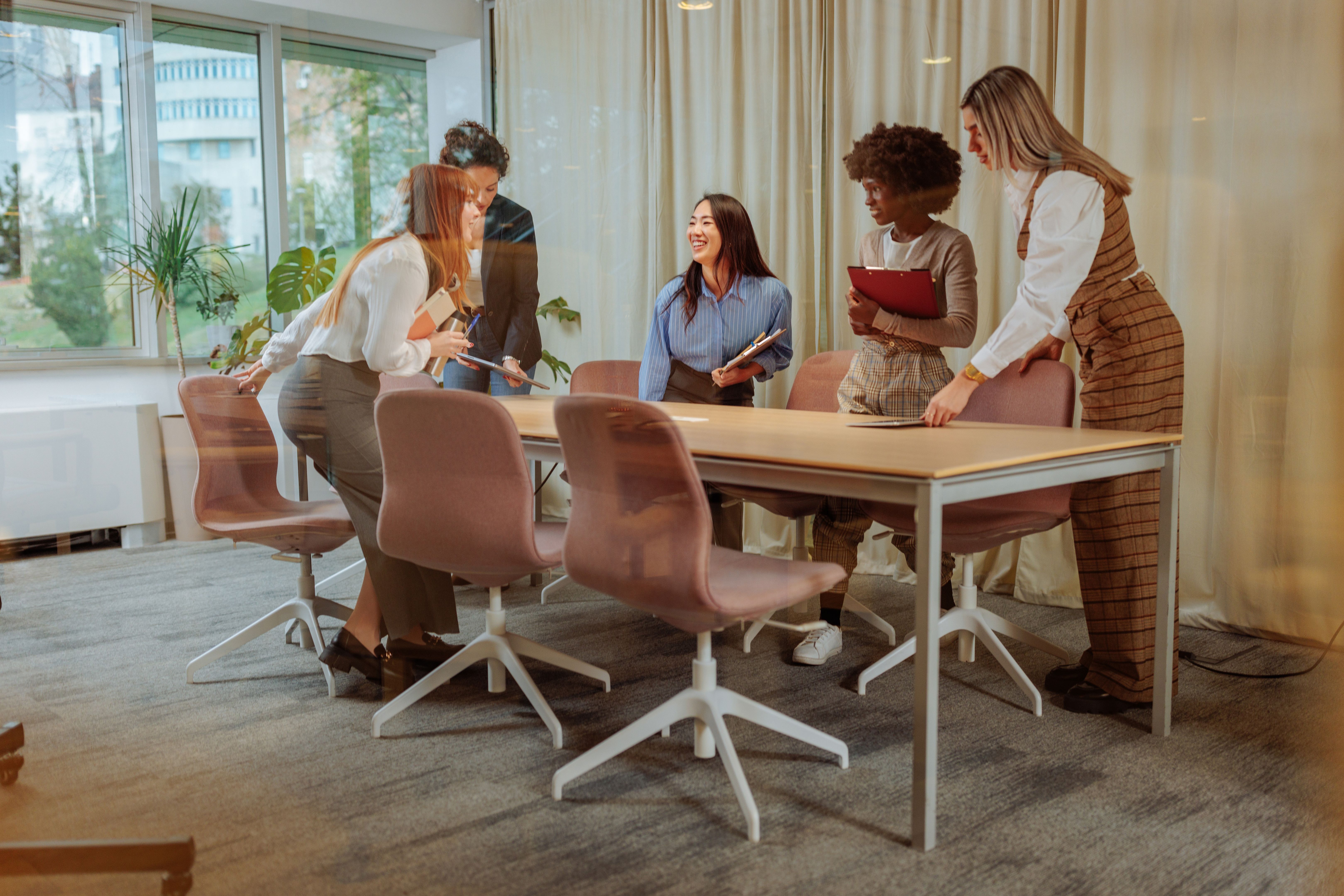 Businesswomen about to sit and have a meeting inside of the glass office