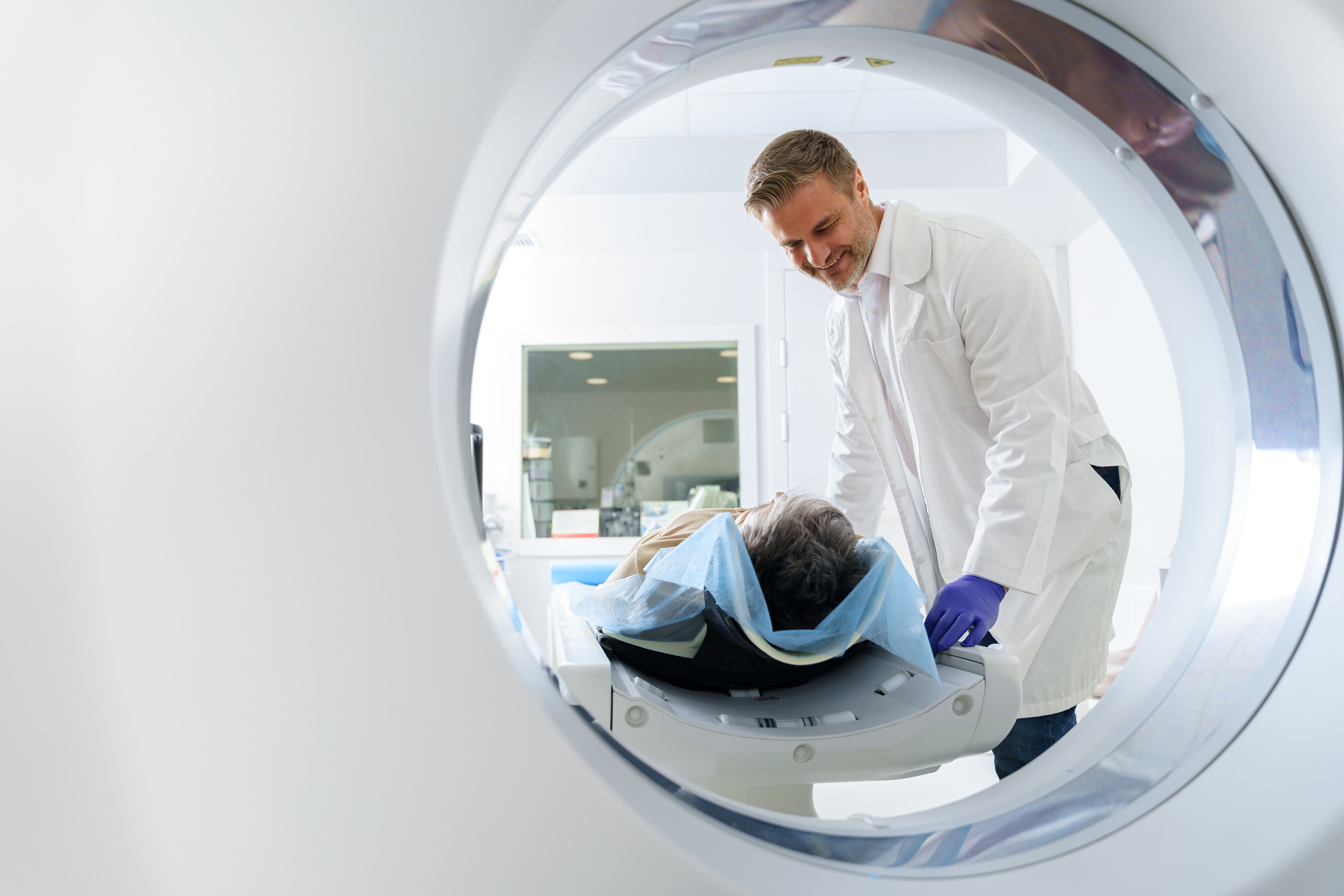 Doctor and female patient in the room of computed tomography at hospital. Healthcare concept