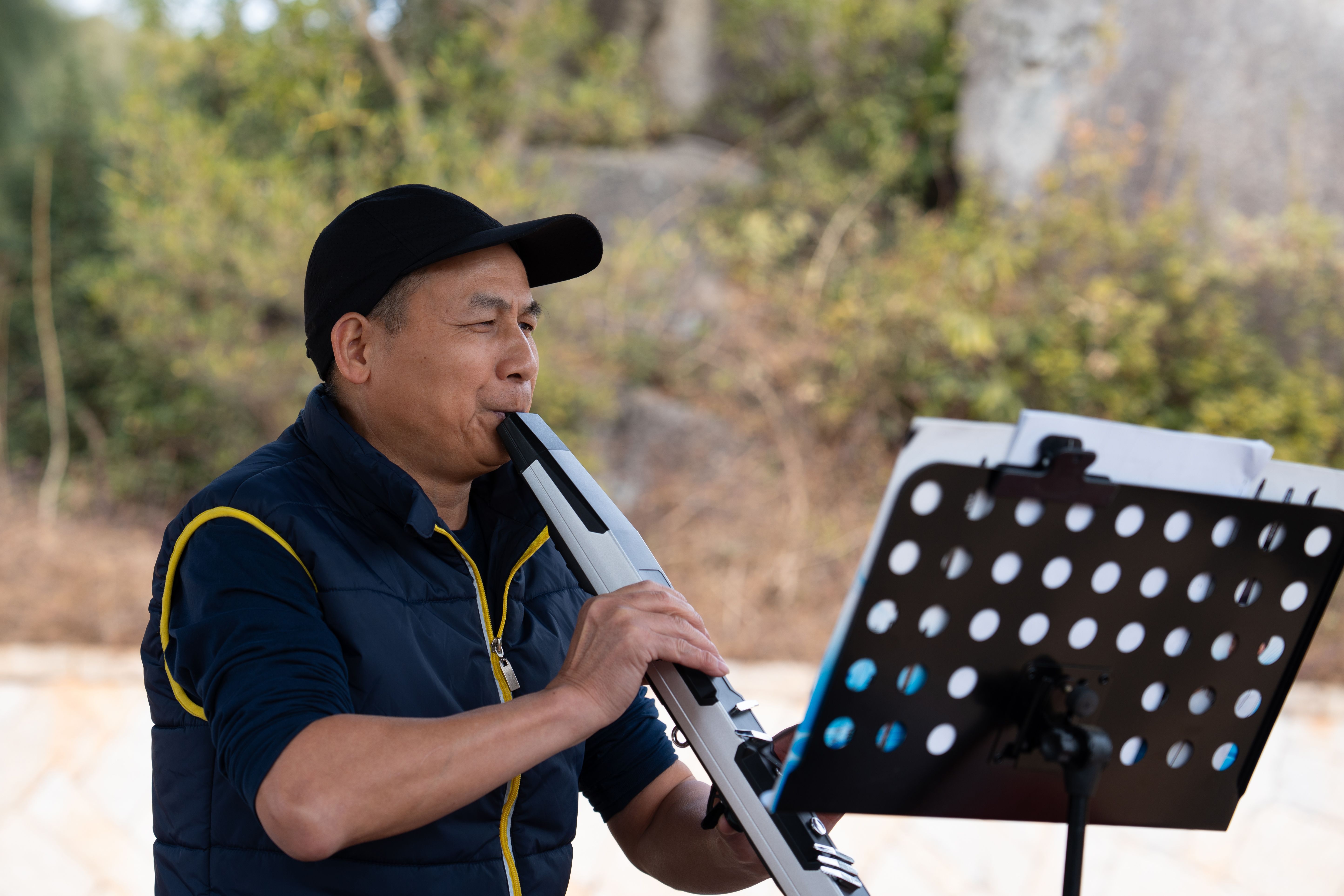 Mature amateur musician playing electronic wind instrument