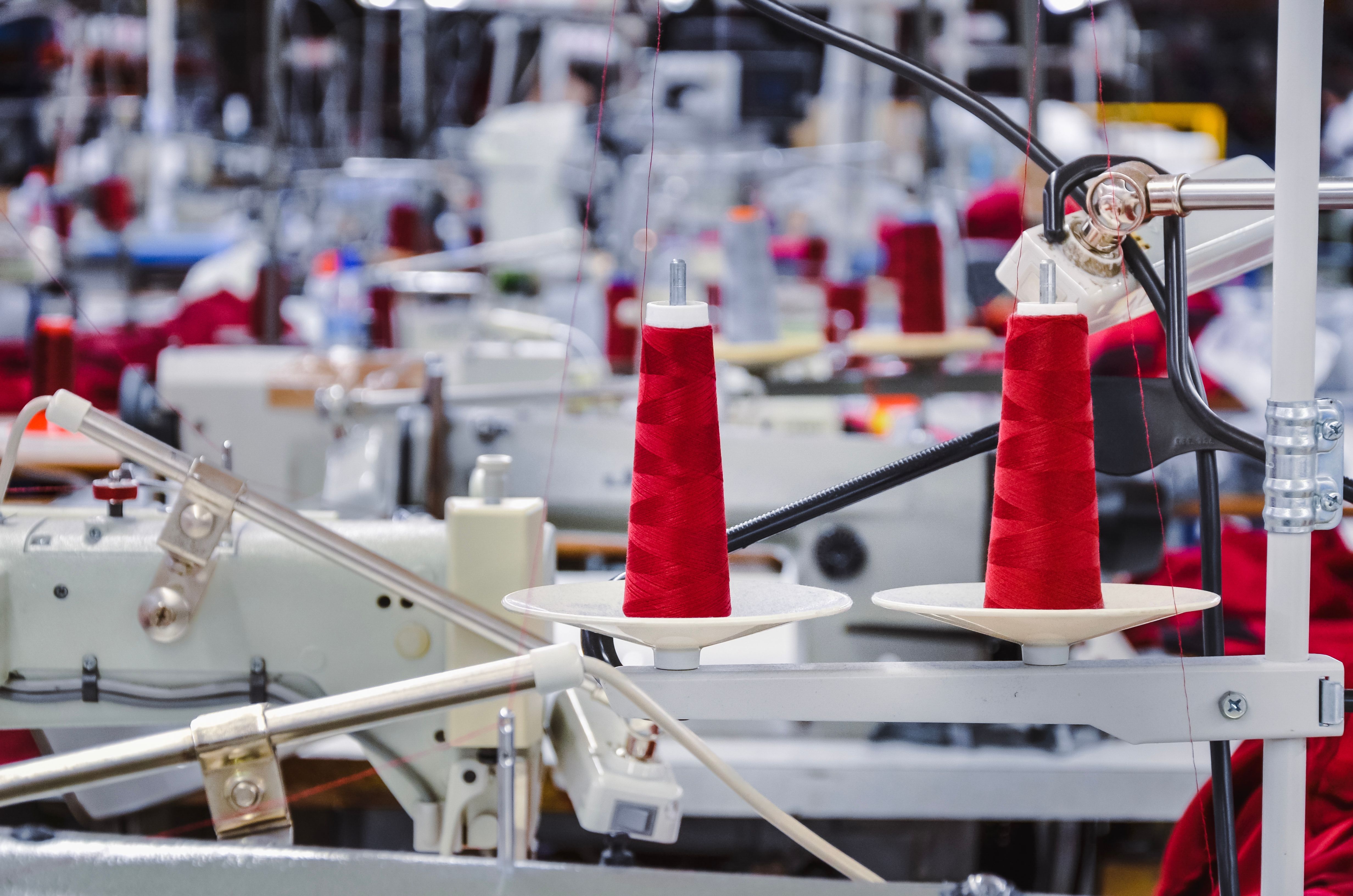 Red threads on a sawing machine in the factory