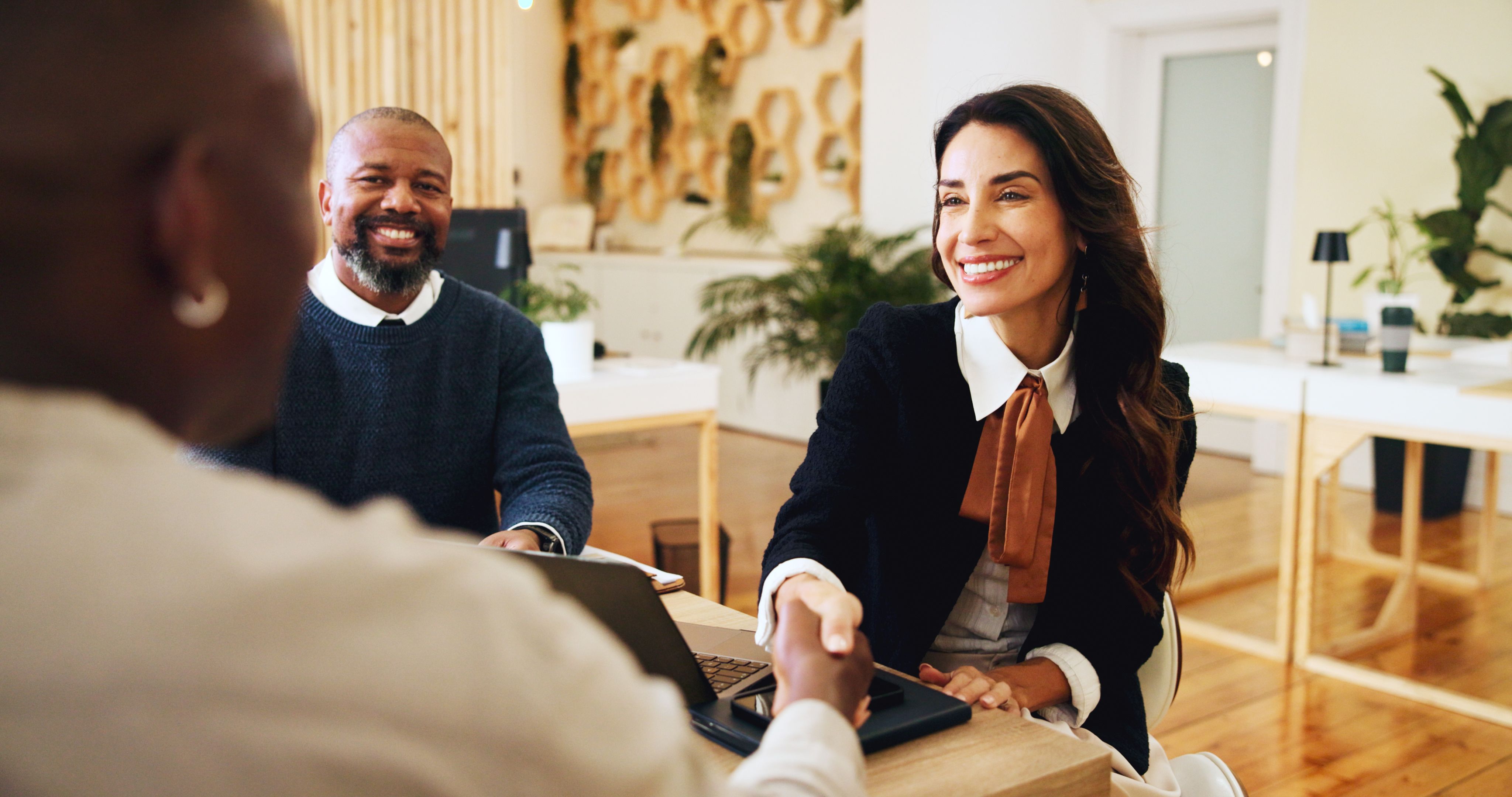 Business professionals shaking hands during a nonprofit partnership meeting, highlighting the role of state charity registration in building trust and securing funding.