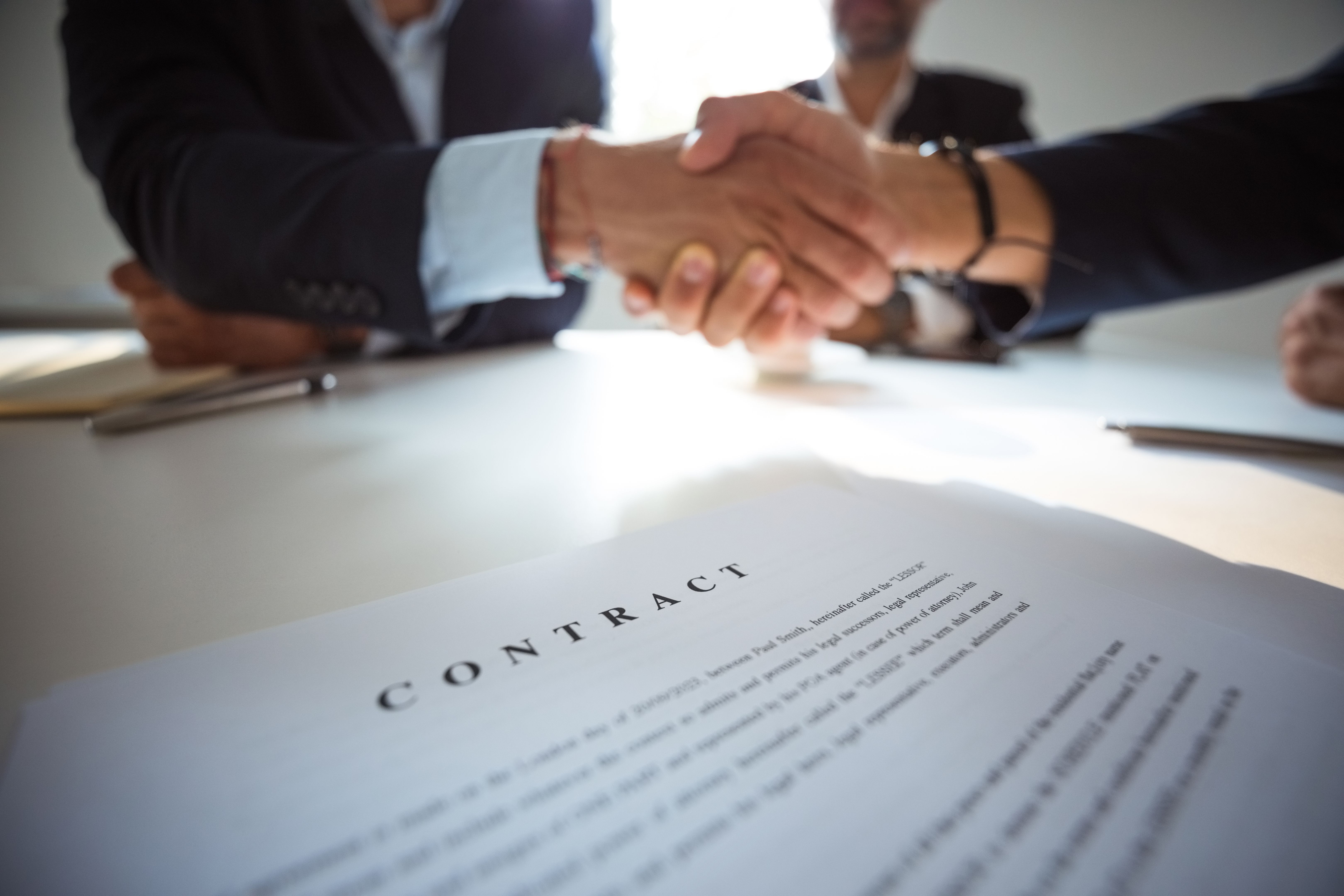 Businessmen shaking hands over contract