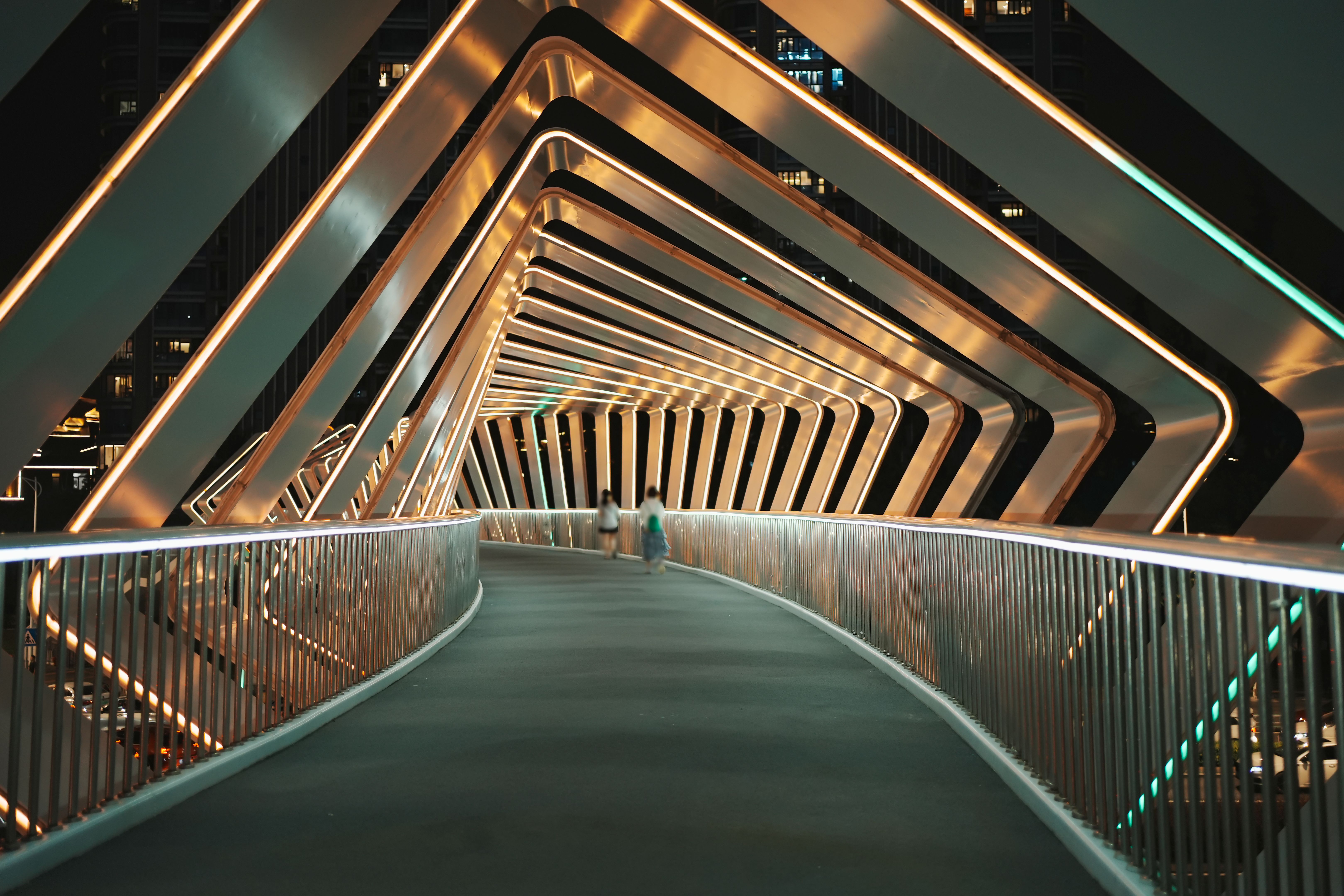 Pedestrians walk on a modern pedestrian bridge