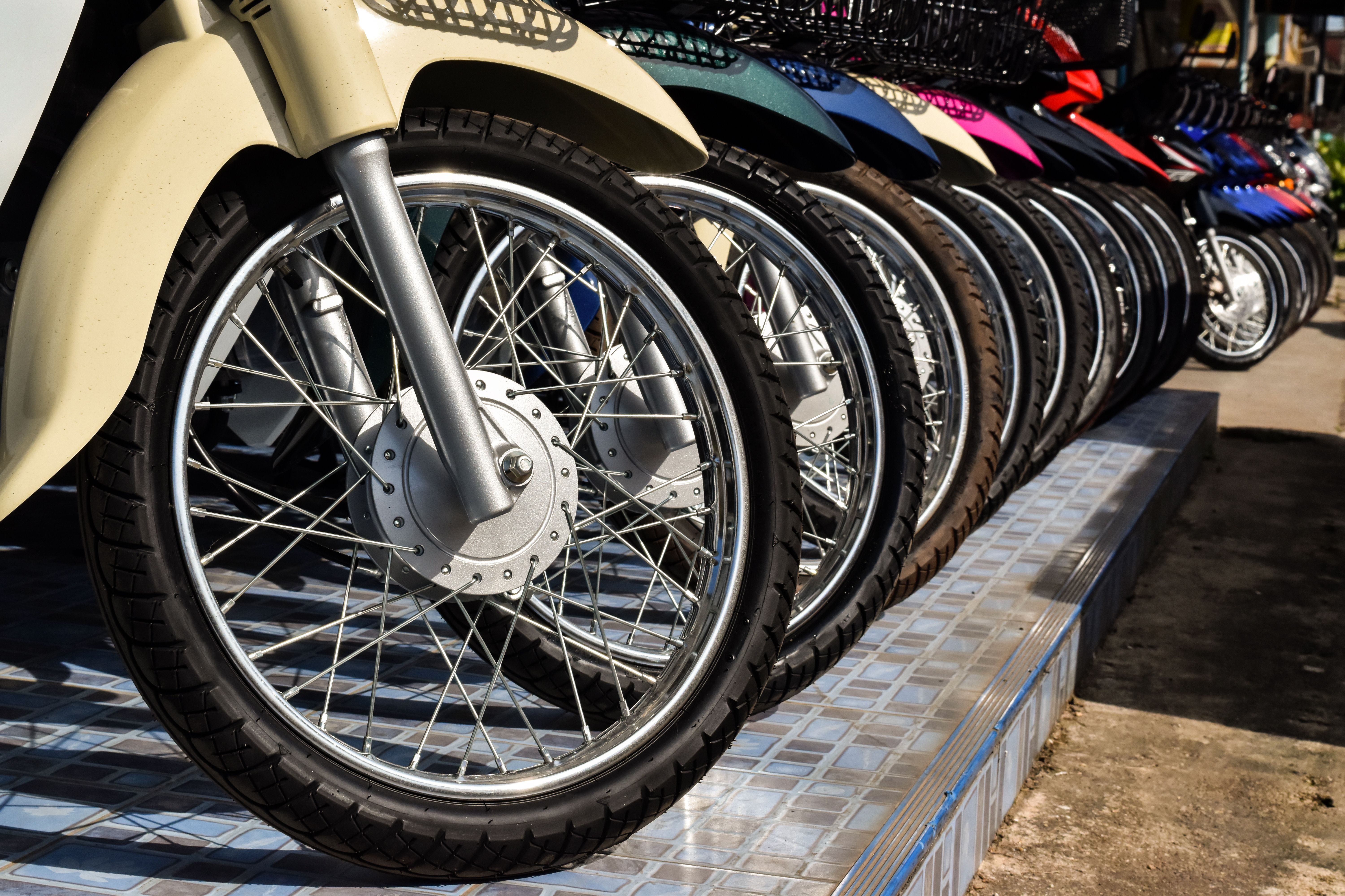 Motorcycles standing in the row. Row of many motorcycle wheel at the Showroom for sale.
