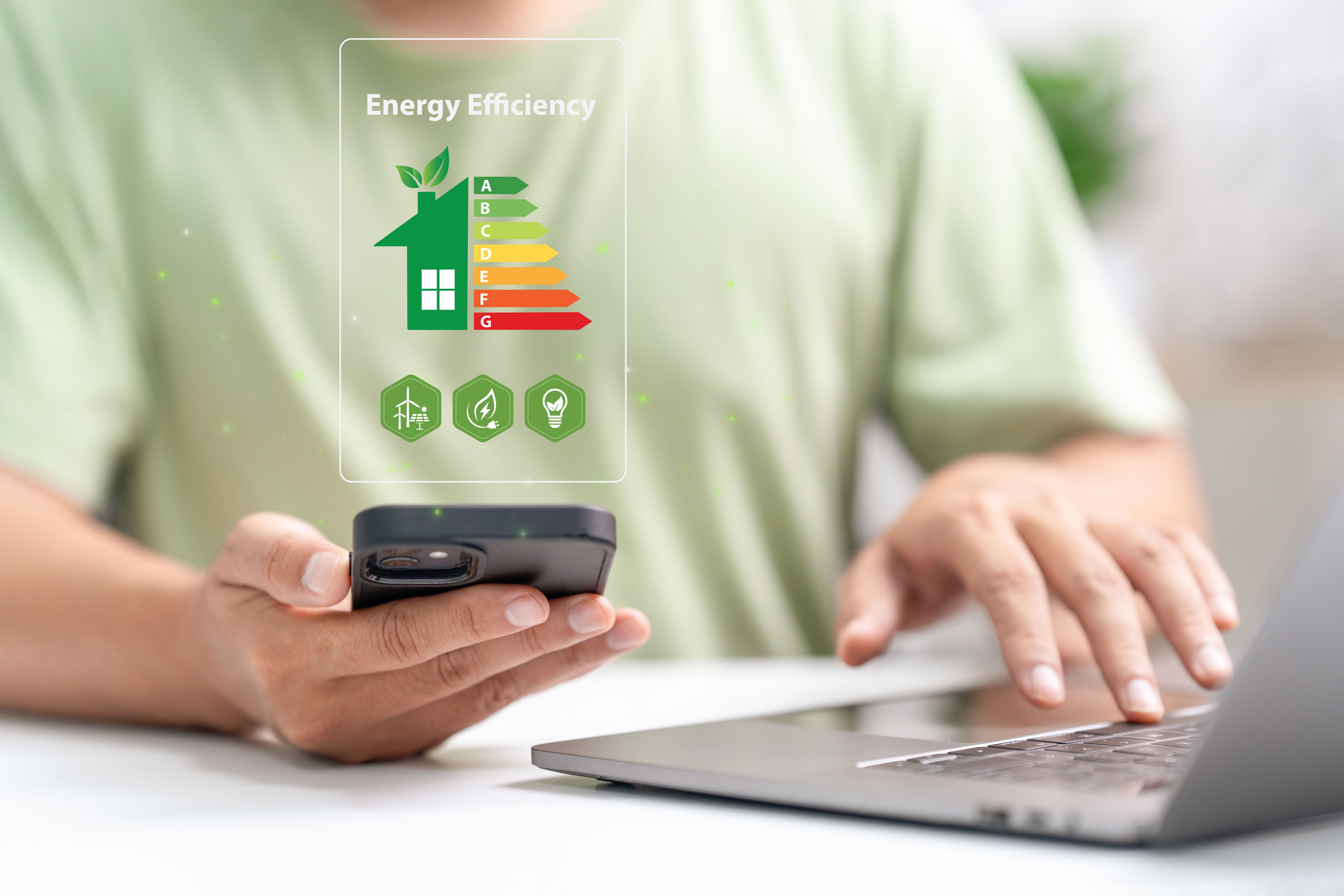 Energy efficiency rating and eco home renovation insulation performance concept. Energy efficiency mobile app on screen. Ecology, eco house and bioenergetic house, efficiency scale.
