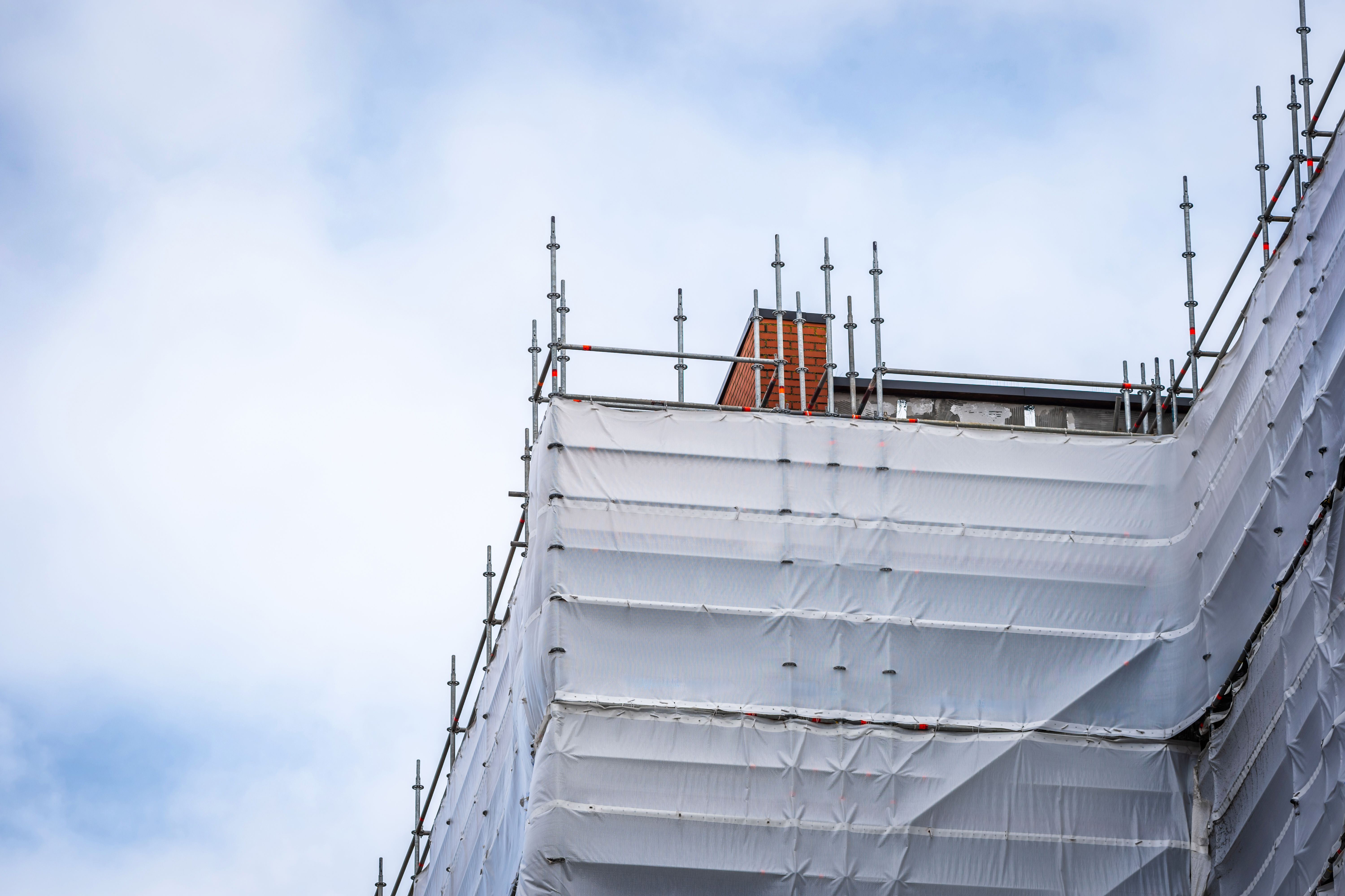 Flame retardant scaffold sheeting wrapped apartments building during insulation in england uk Flame retardant scaffold sheeting wrapped apartments building during insulation in england uk
