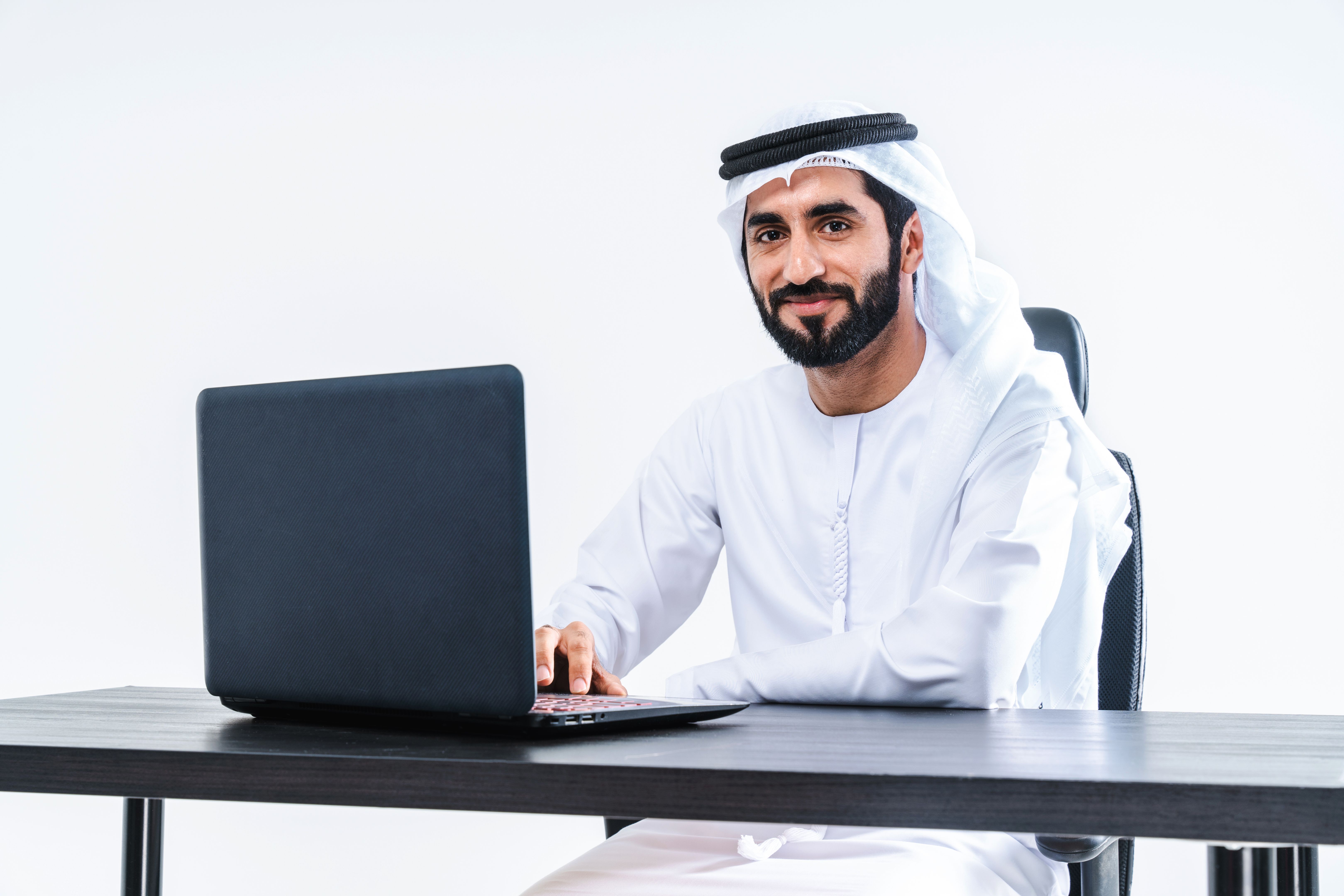 Emirate middle-eastern businessman wearing kandora working in the office, Dubai
