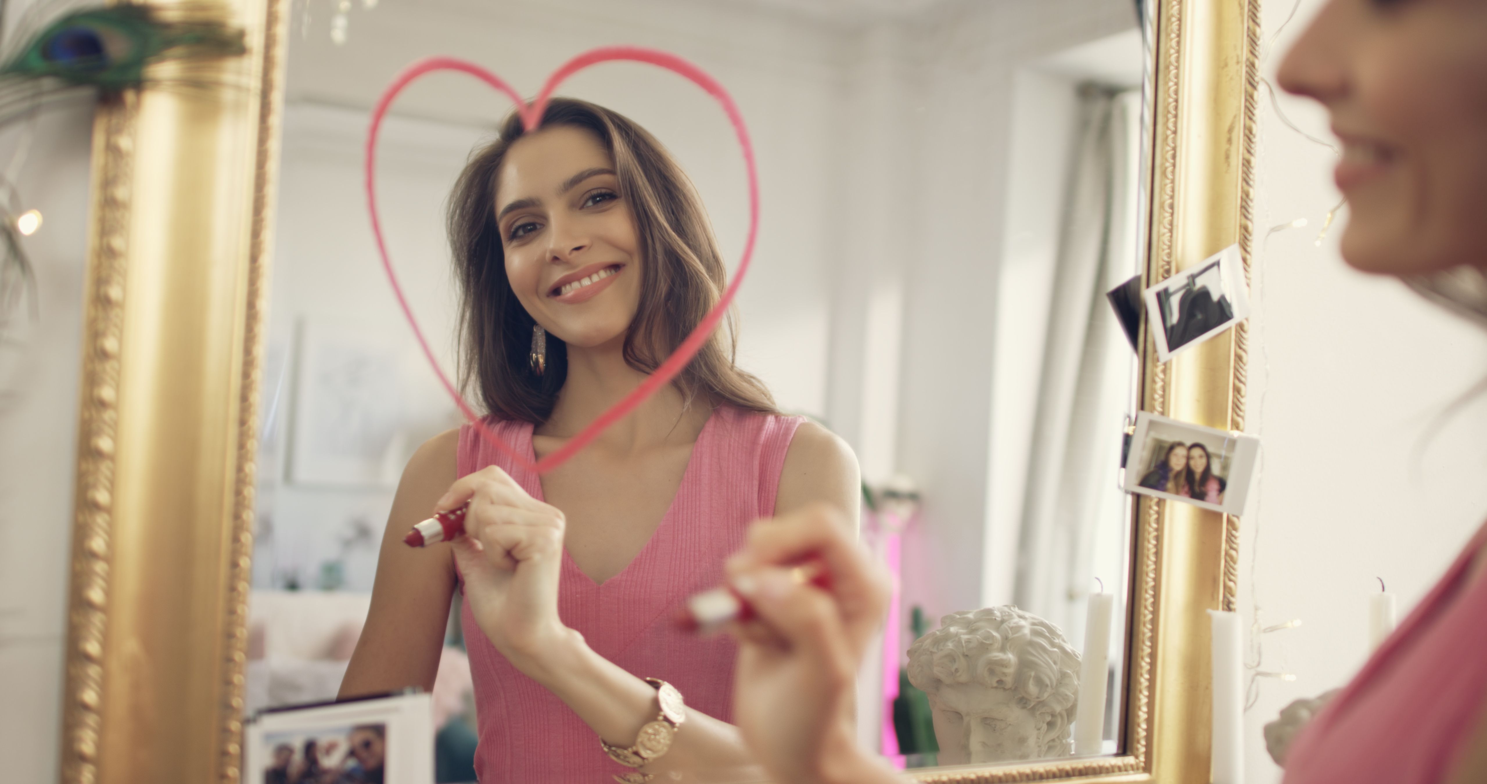 Woman in love. Drawing lipstick heart on a mirror Woman in love. Drawing lipstick heart on a mirror