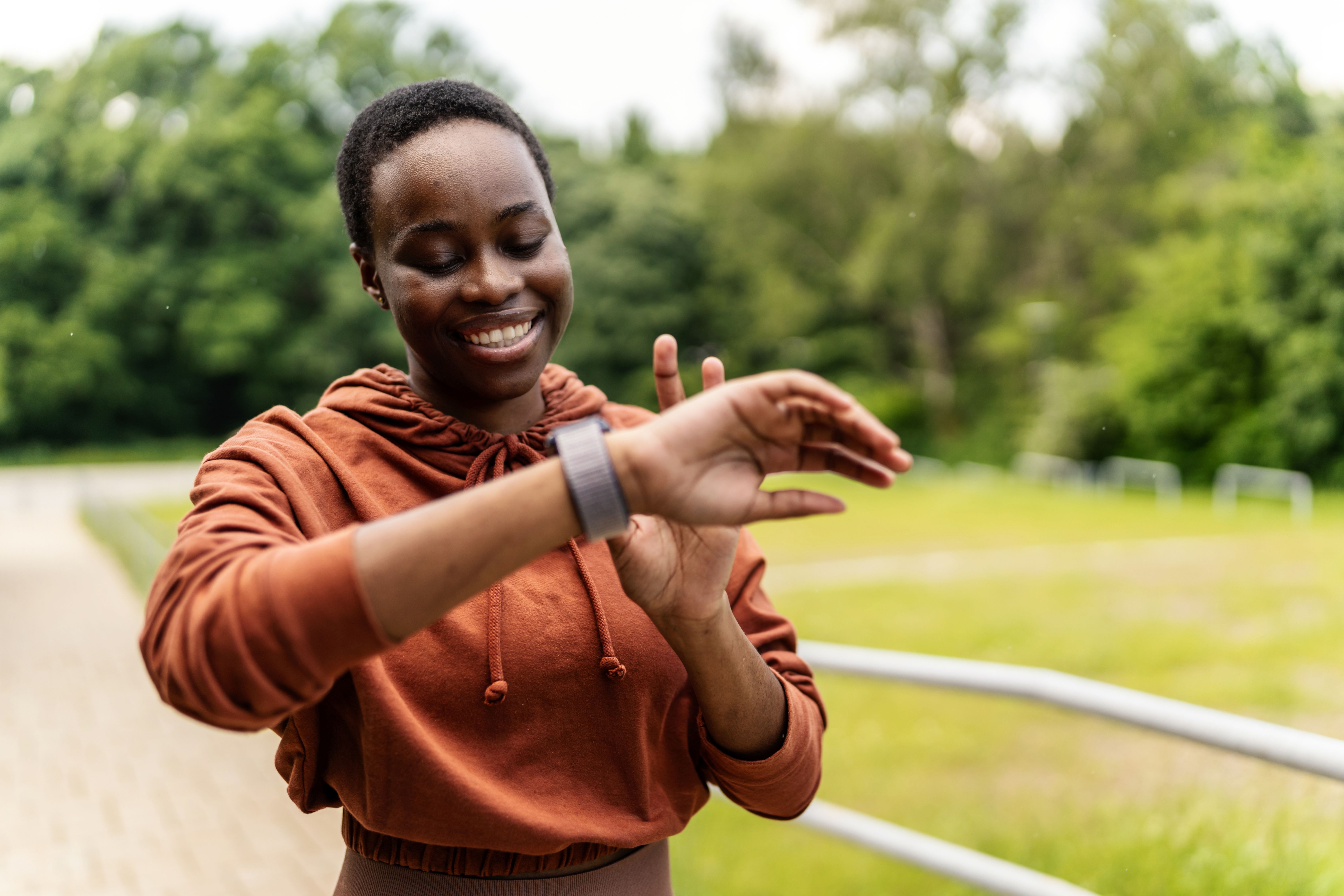 African American jogger getting ready for workout looking at smart watch. African American jogger getting ready for workout looking at smart watch.