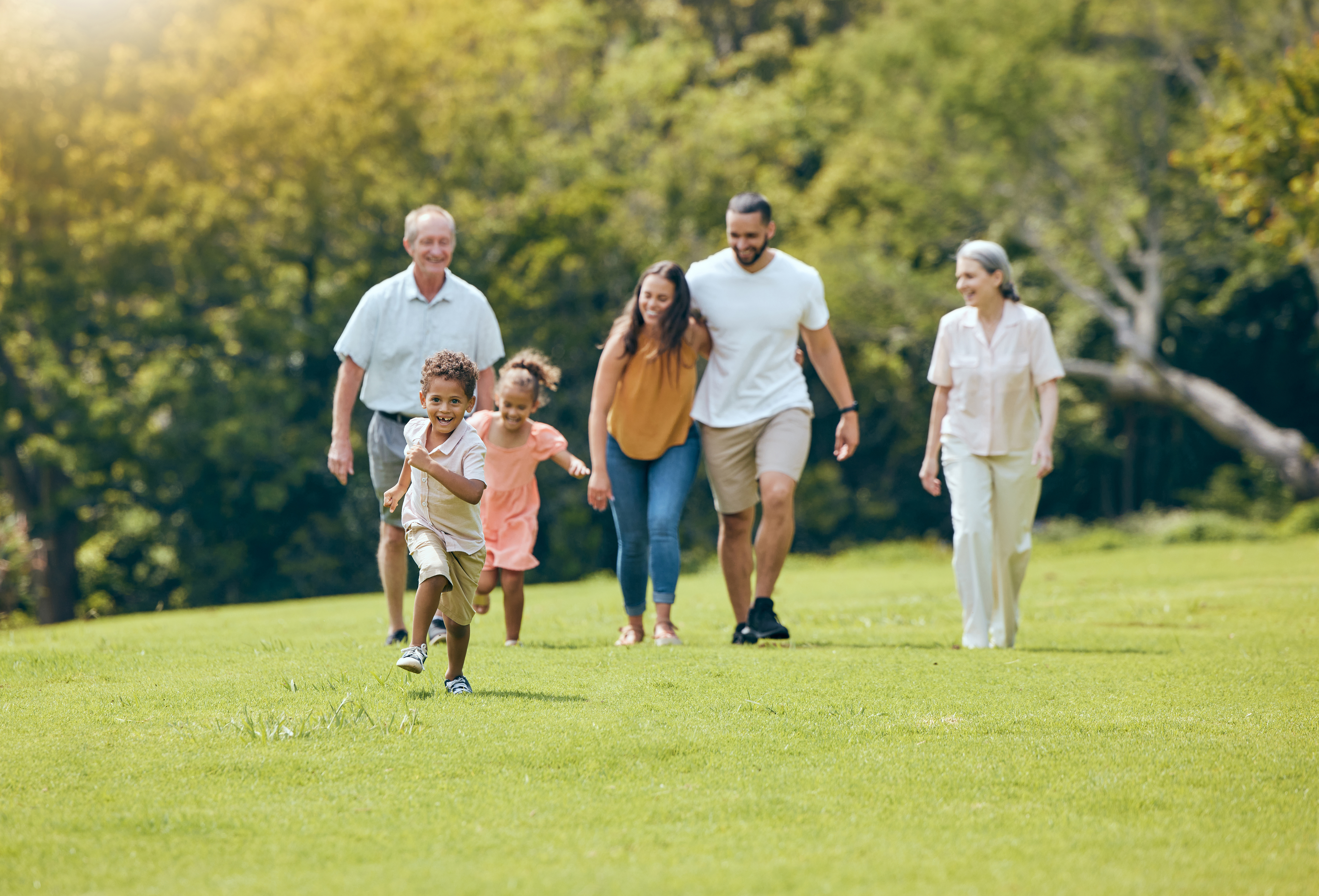 Grandparents, parents and children walking in park, happy and bonding outdoor, loving together and quality time. Family, love and vacation in summer with smile, laugh and have fun with kids and relax