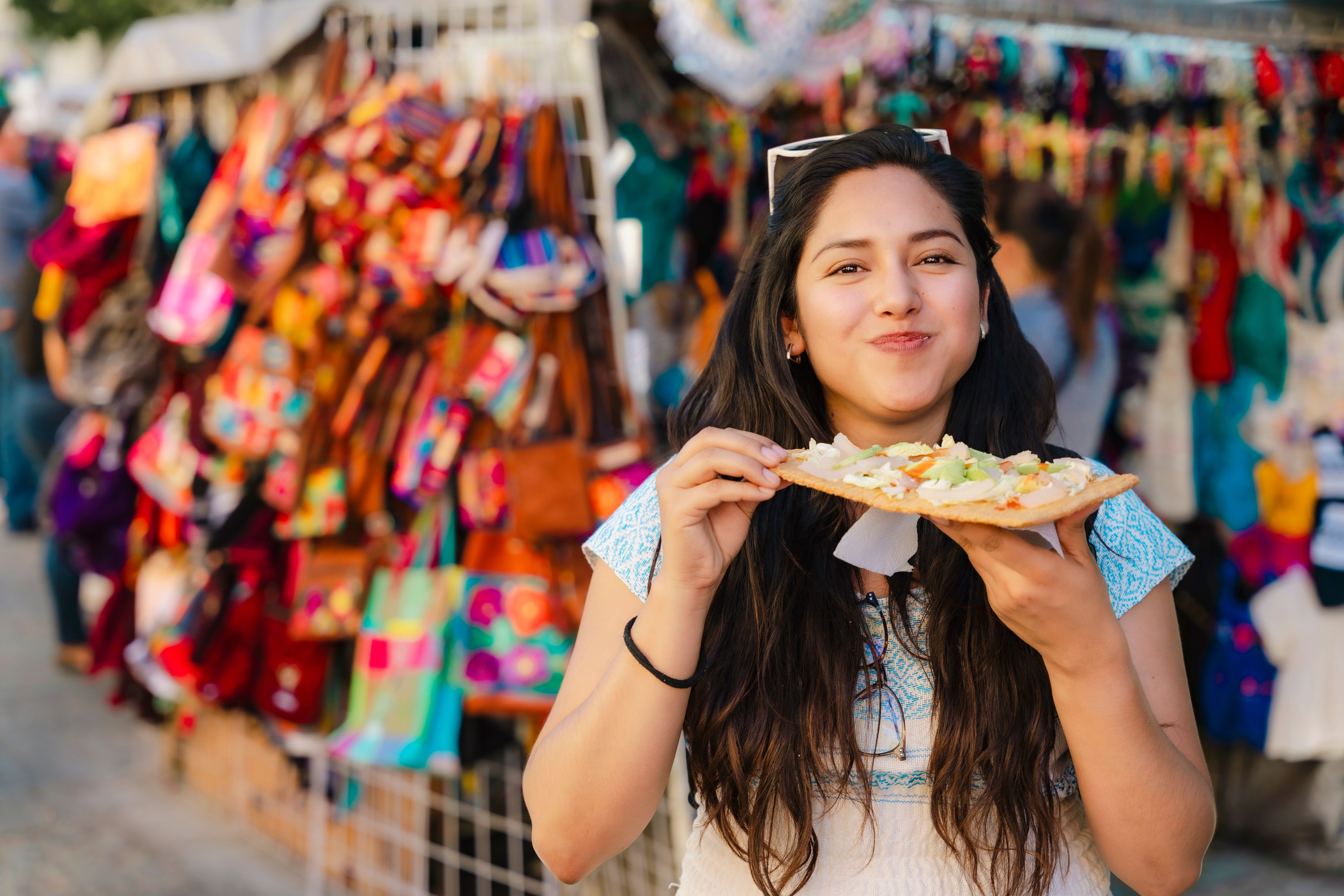 Latina Woman Eating Tlayuda in Market
