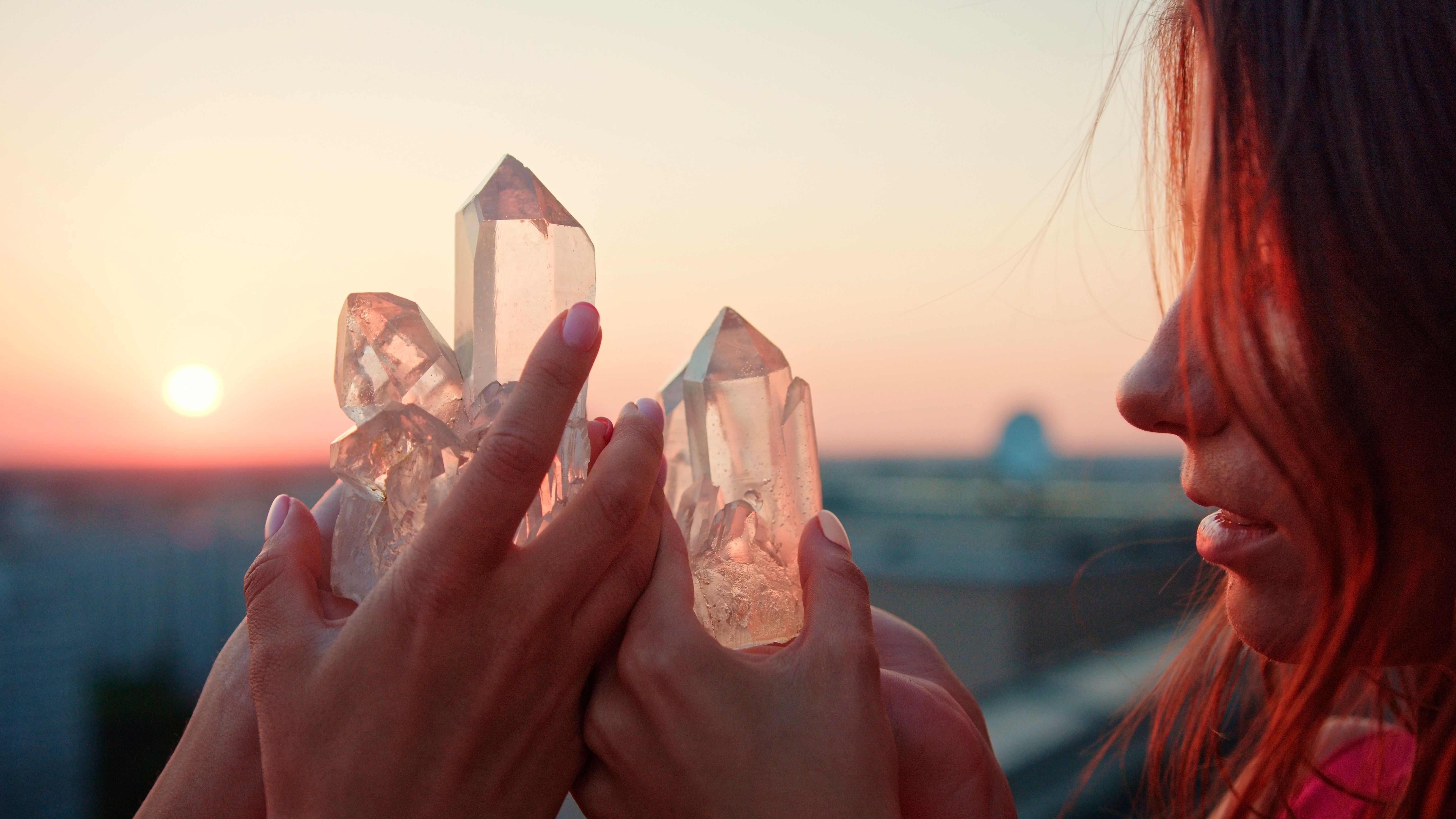 Sisters meditating with healing crystals. Rooftop view