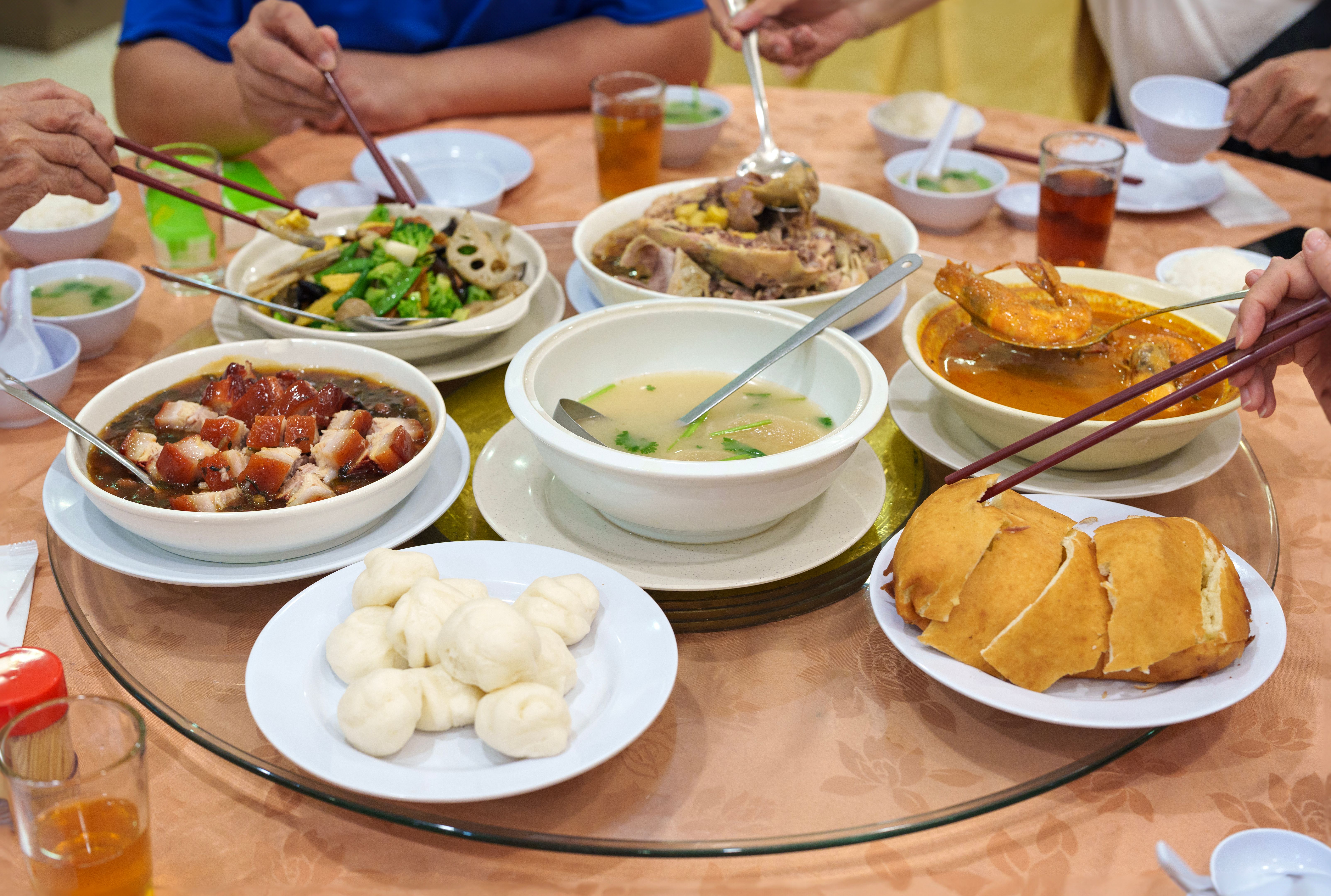 Close-up of a joyful Asian family having a reunion dinner together in the dining room of a Chinese restaurant