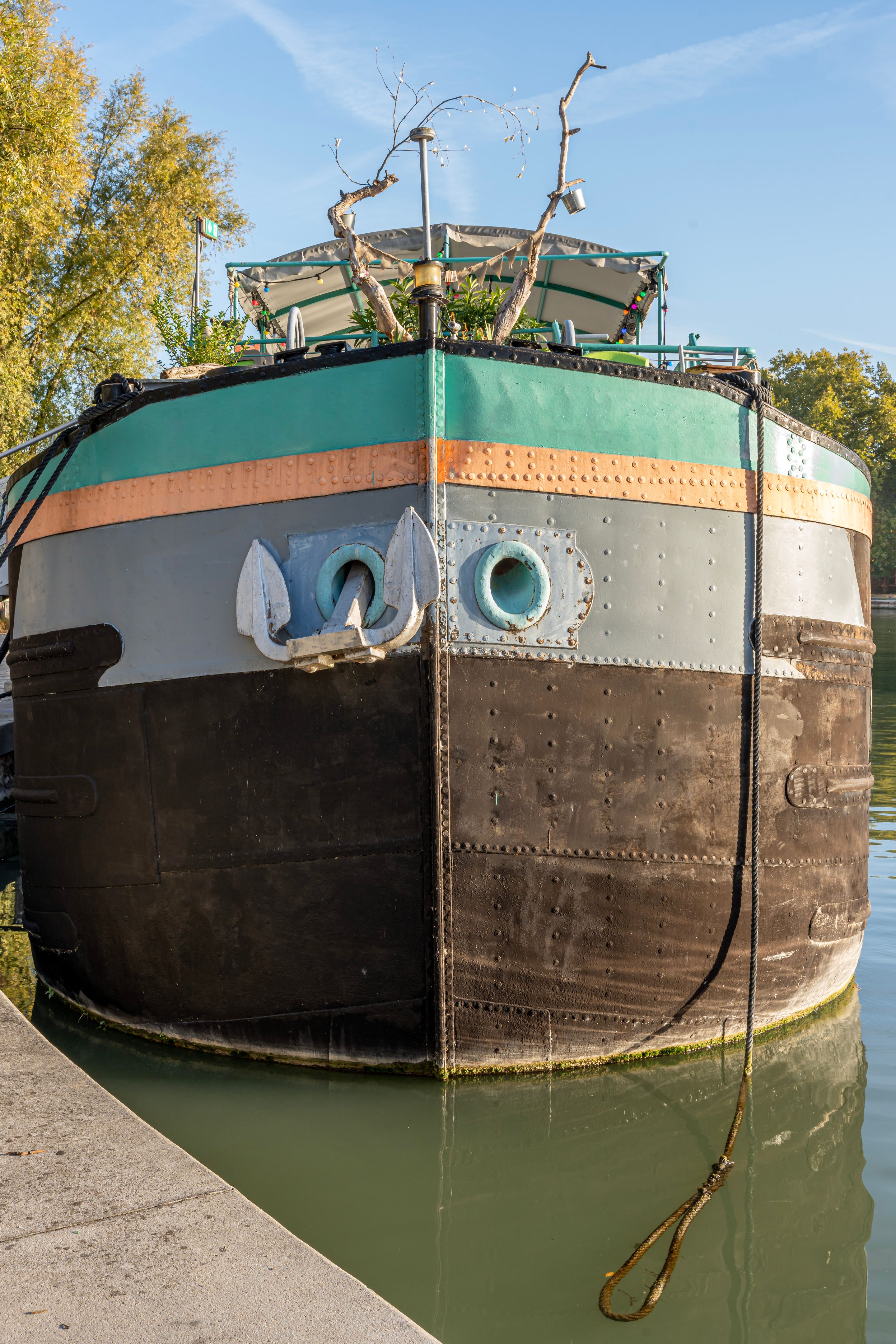 Paris, France - 10 07 2022: Ourcq Canal. Detail of the colorful hull of a boat Paris, France - 10 07 2022: Ourcq Canal. Detail of the colorful hull of a boat