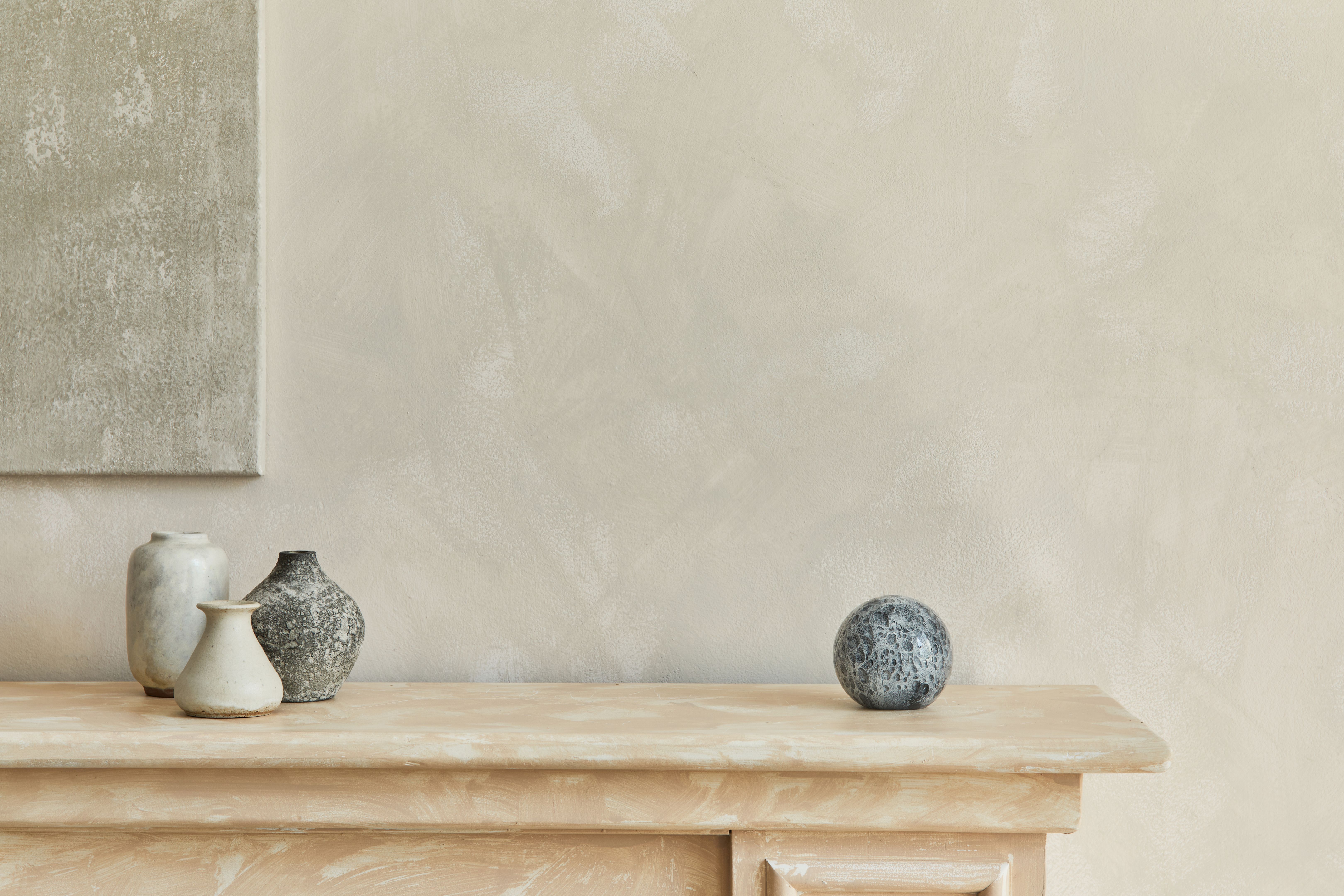 Stylish modern composition of living room interior with copy space, lamp on he wooden cube and personal accessories. Neutral colours. Template.