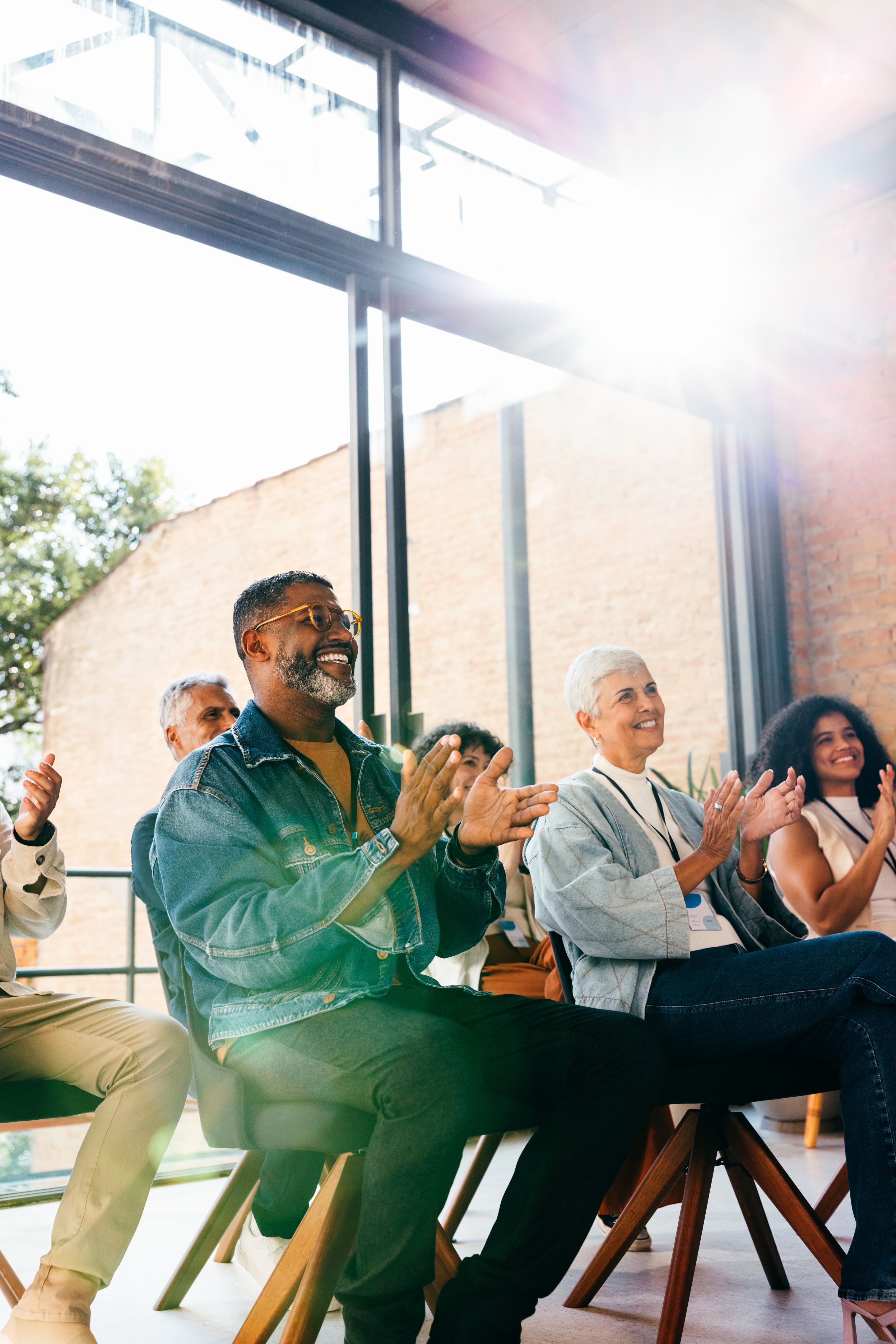 Colleagues attending seminar clapping in praise during assembly