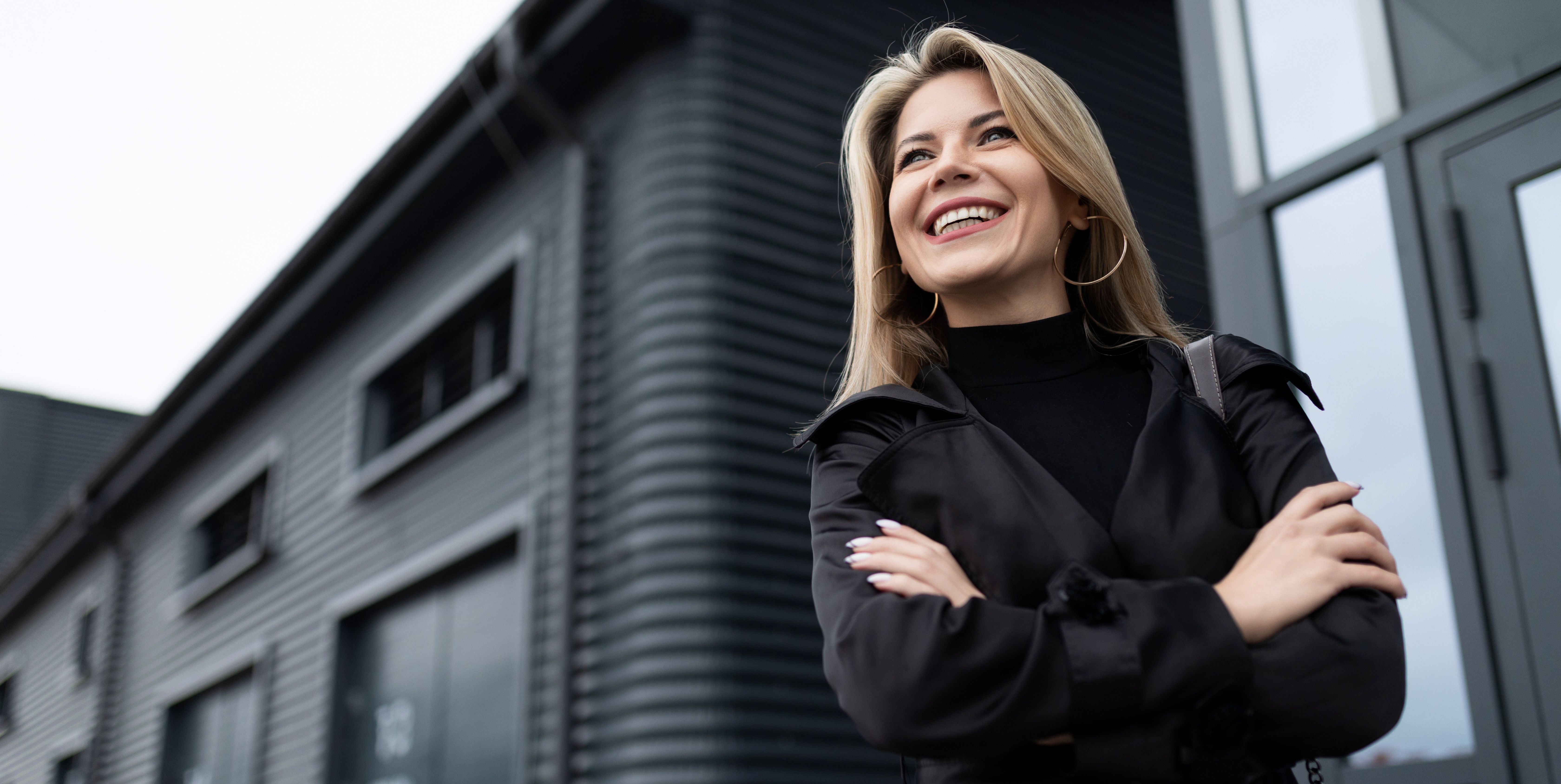 portrait of a mature woman head with a wide smile on her face in business clothes against the backdrop of the facade of a business center, concept of a strong successful woman portrait of a mature woman head with a wide smile on her face in business clothes against the backdrop of the facade of a business center, concept of a strong successful woman