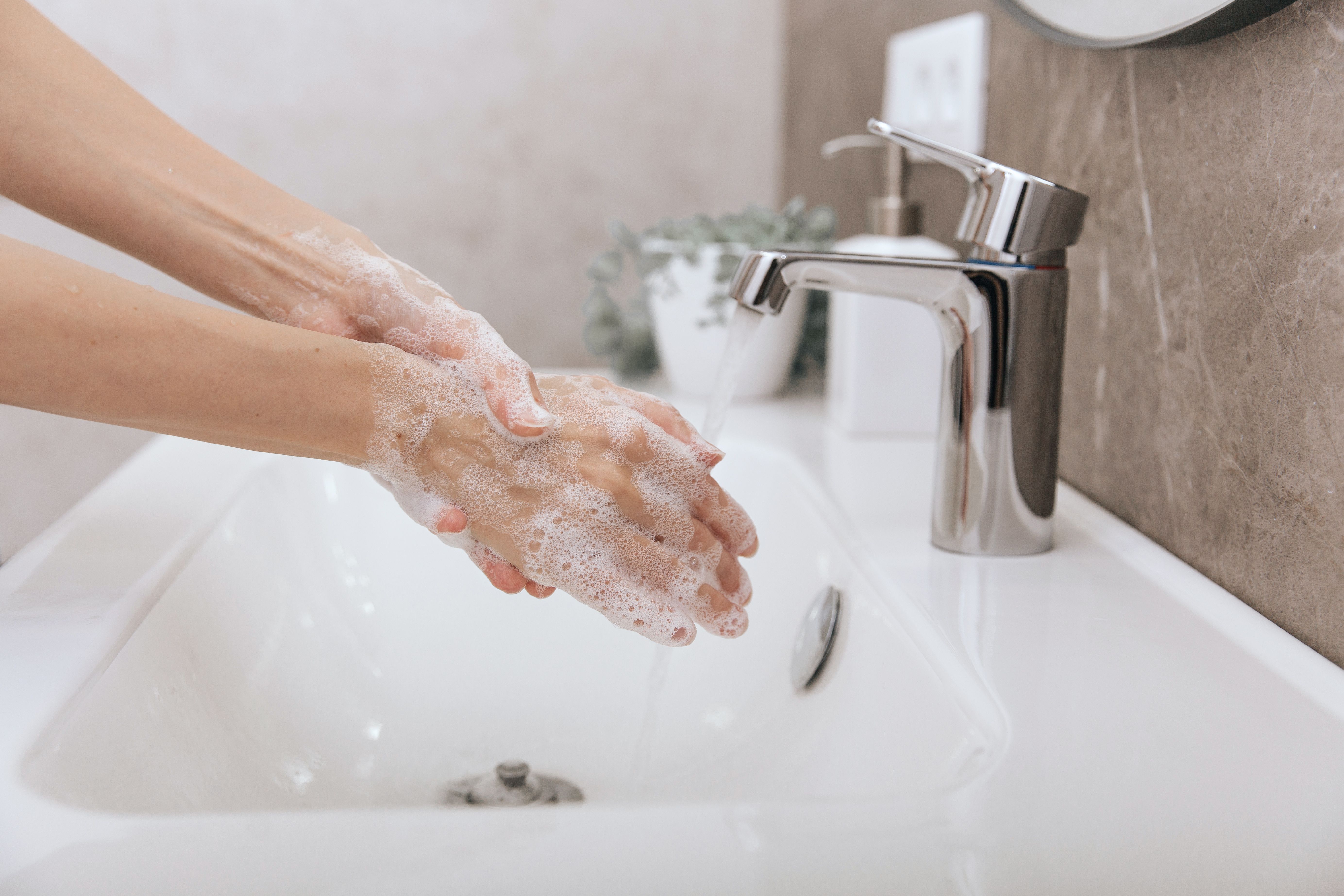 Washing hands under the flowing water tap. Hygiene concept hand detail. Washing hands rubbing with soap for corona virus prevention, hygiene to stop spreading corona virus in or public wash room