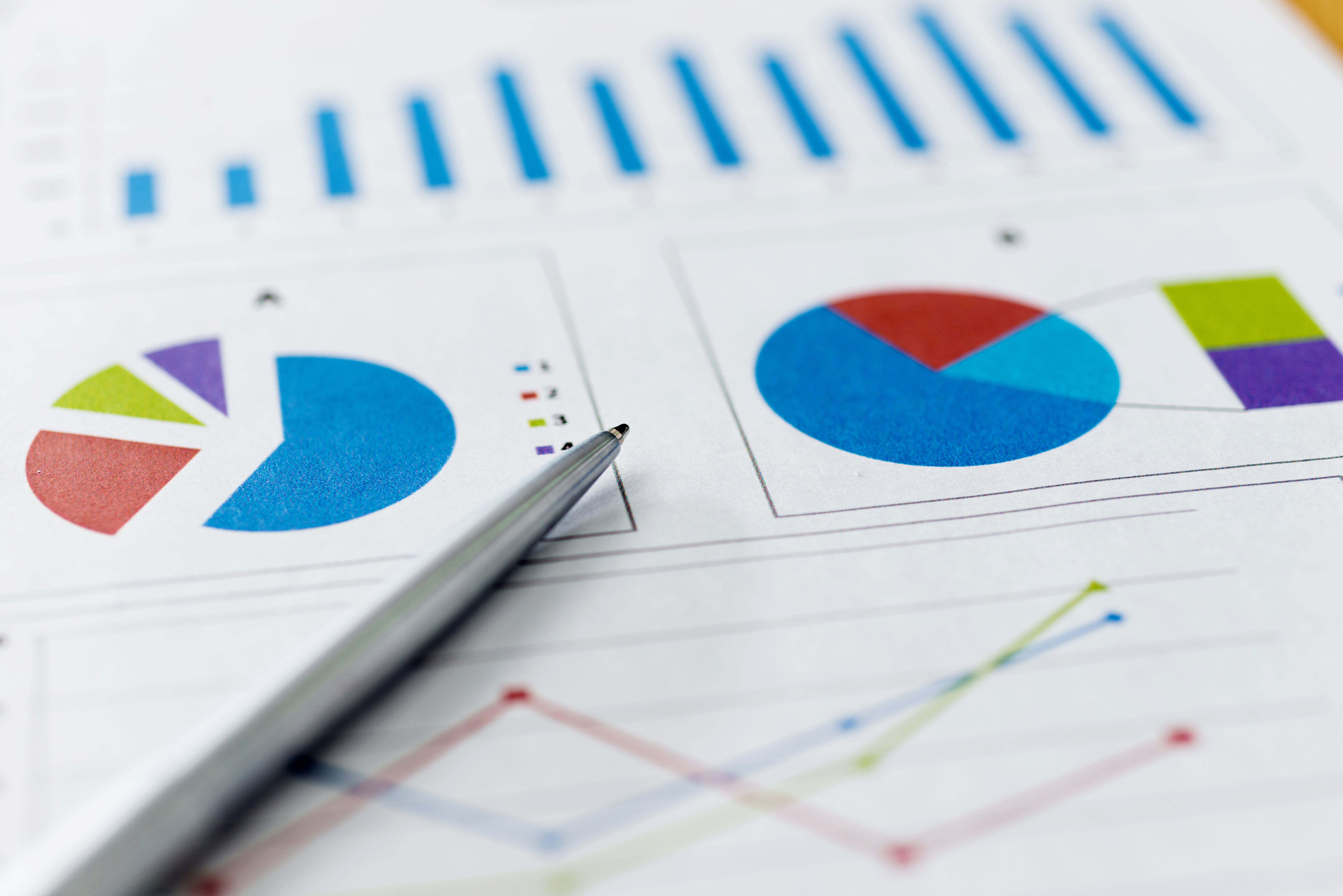 Pen on financial graphs and charts
