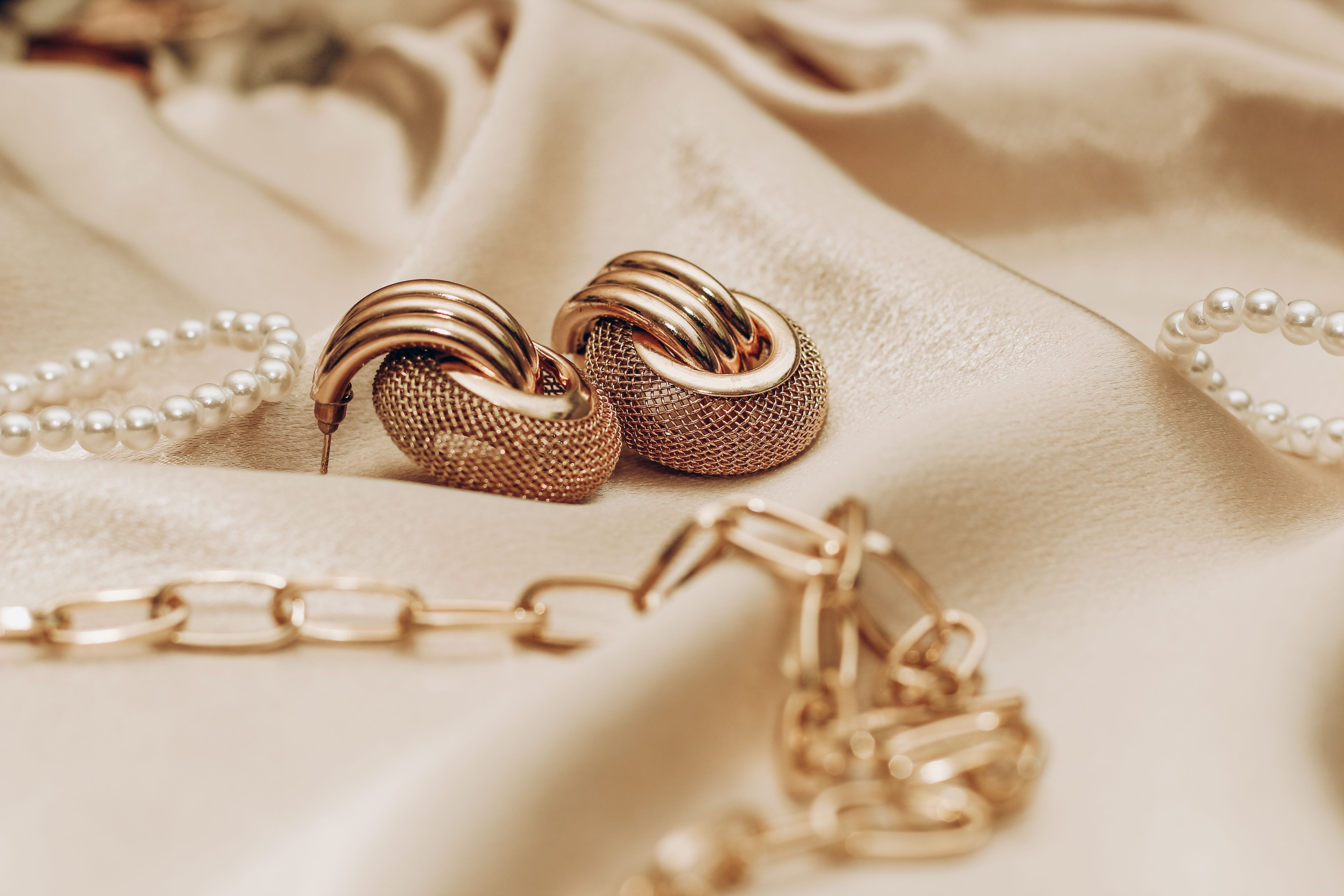 Women's jewelry, gold chain, trendy jewelry on a silk background