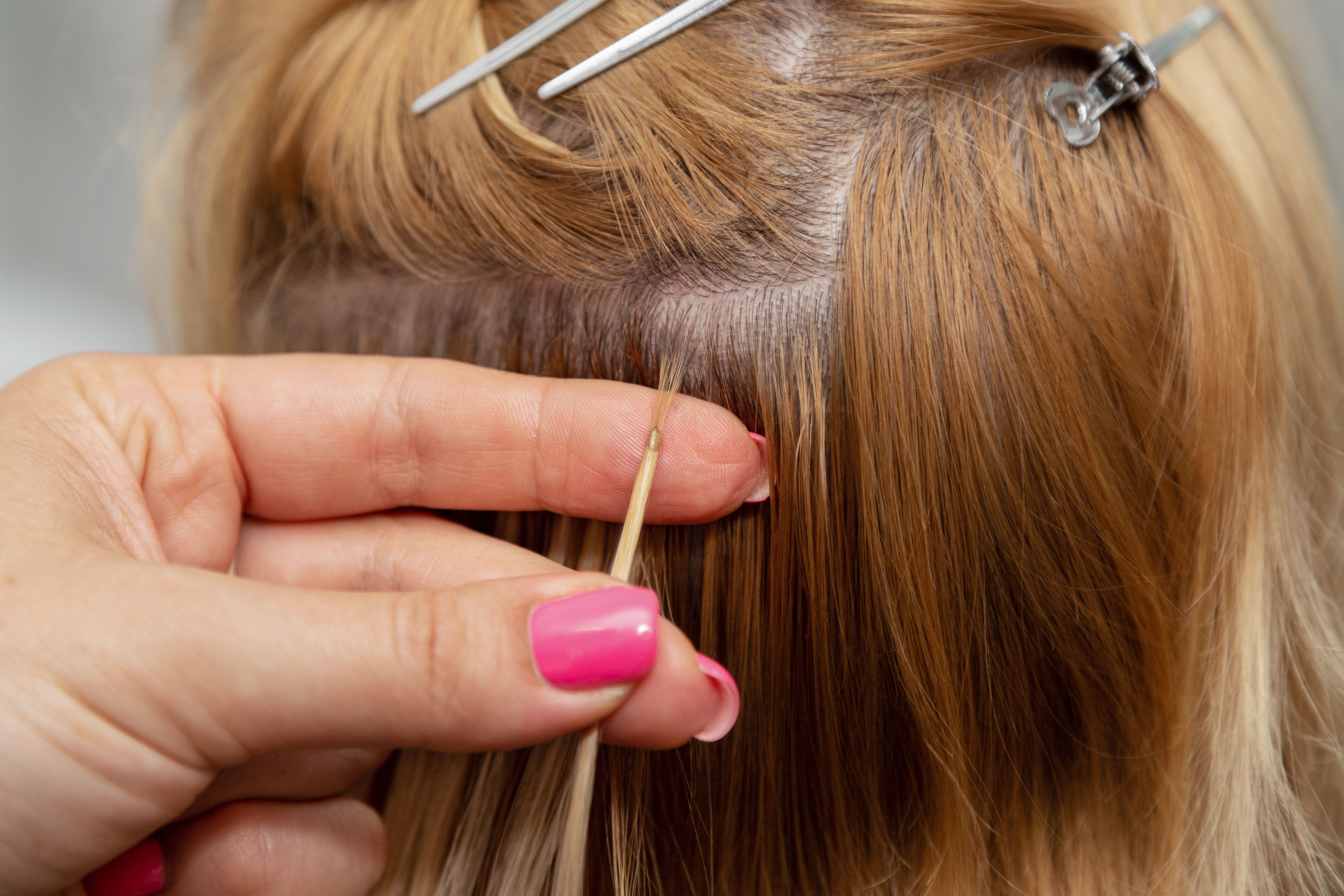 hair stylist applying extensions