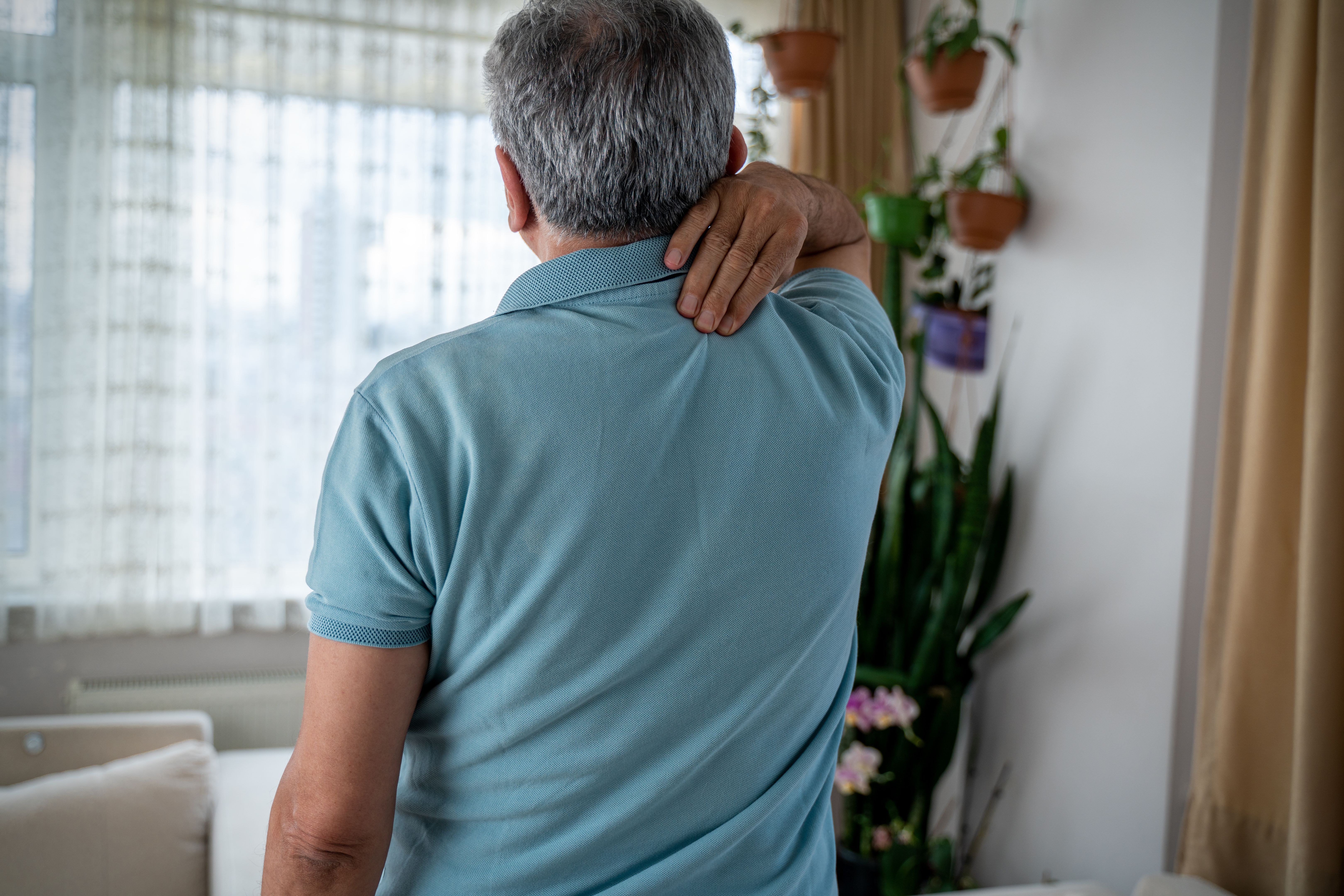 senior man holding his neck in pain