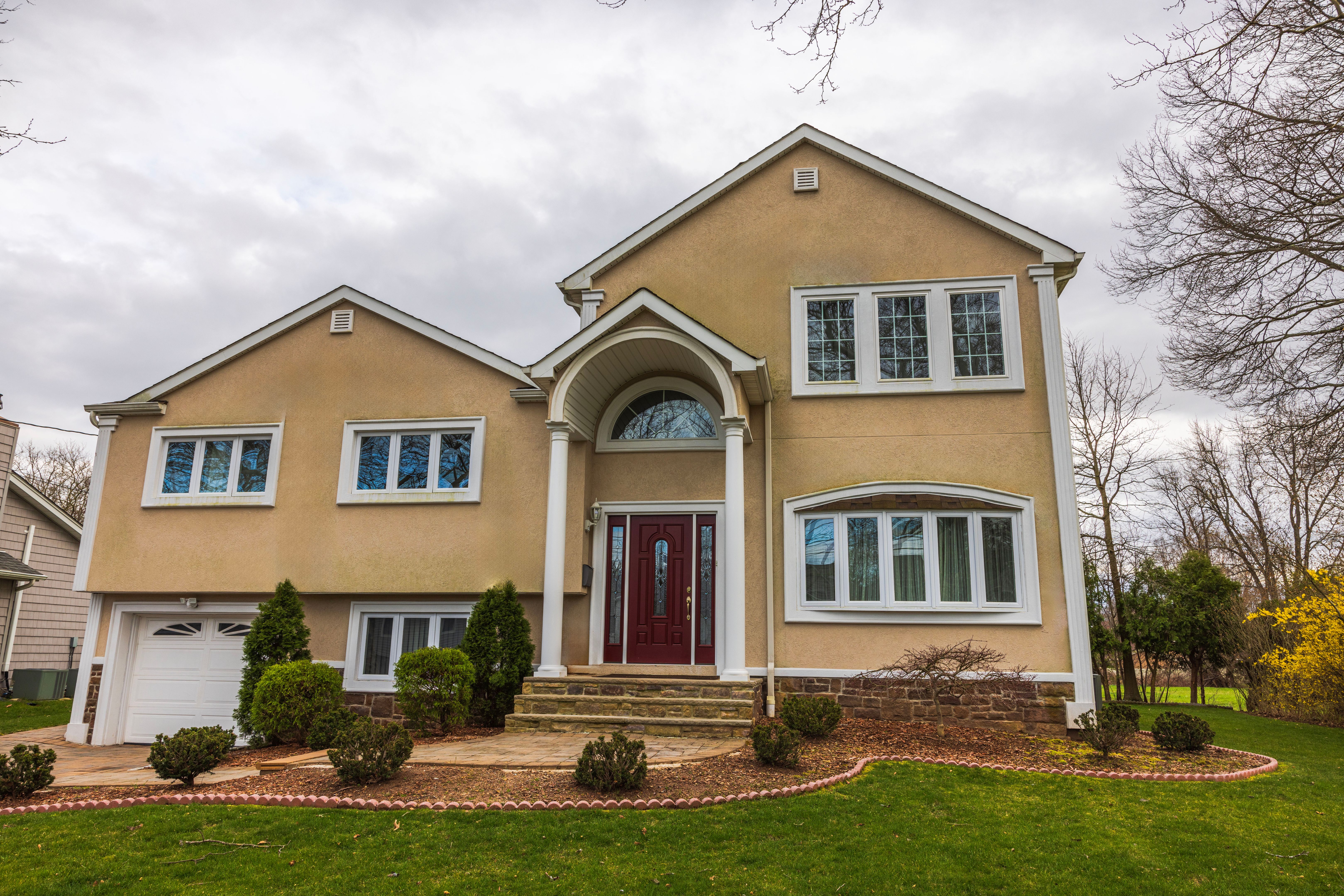Beautiful view of a modern villa overlooking a spring garden against a cloudy sky. New Jersey. USA.