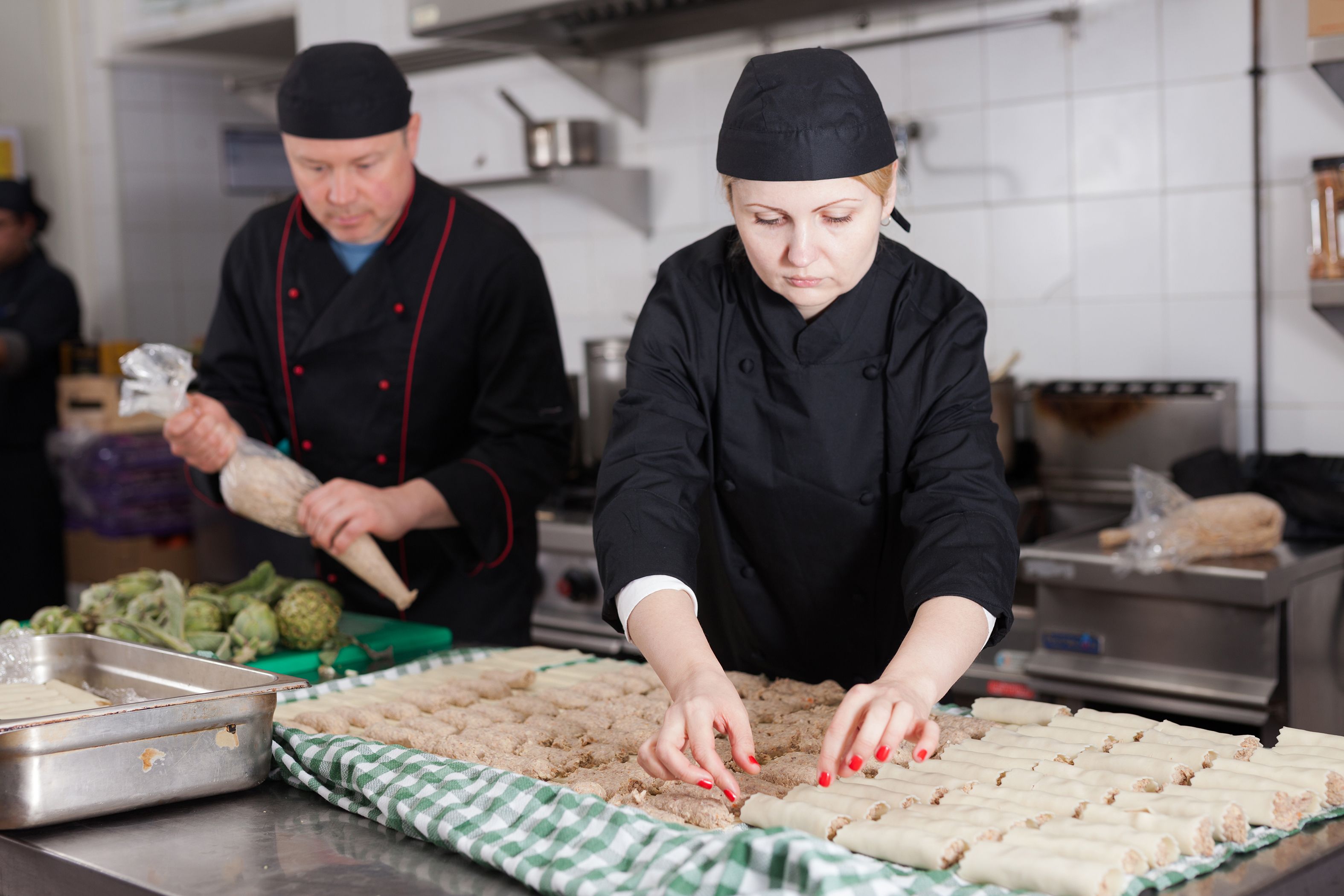 Femme cuisinière remplissant cannelloni