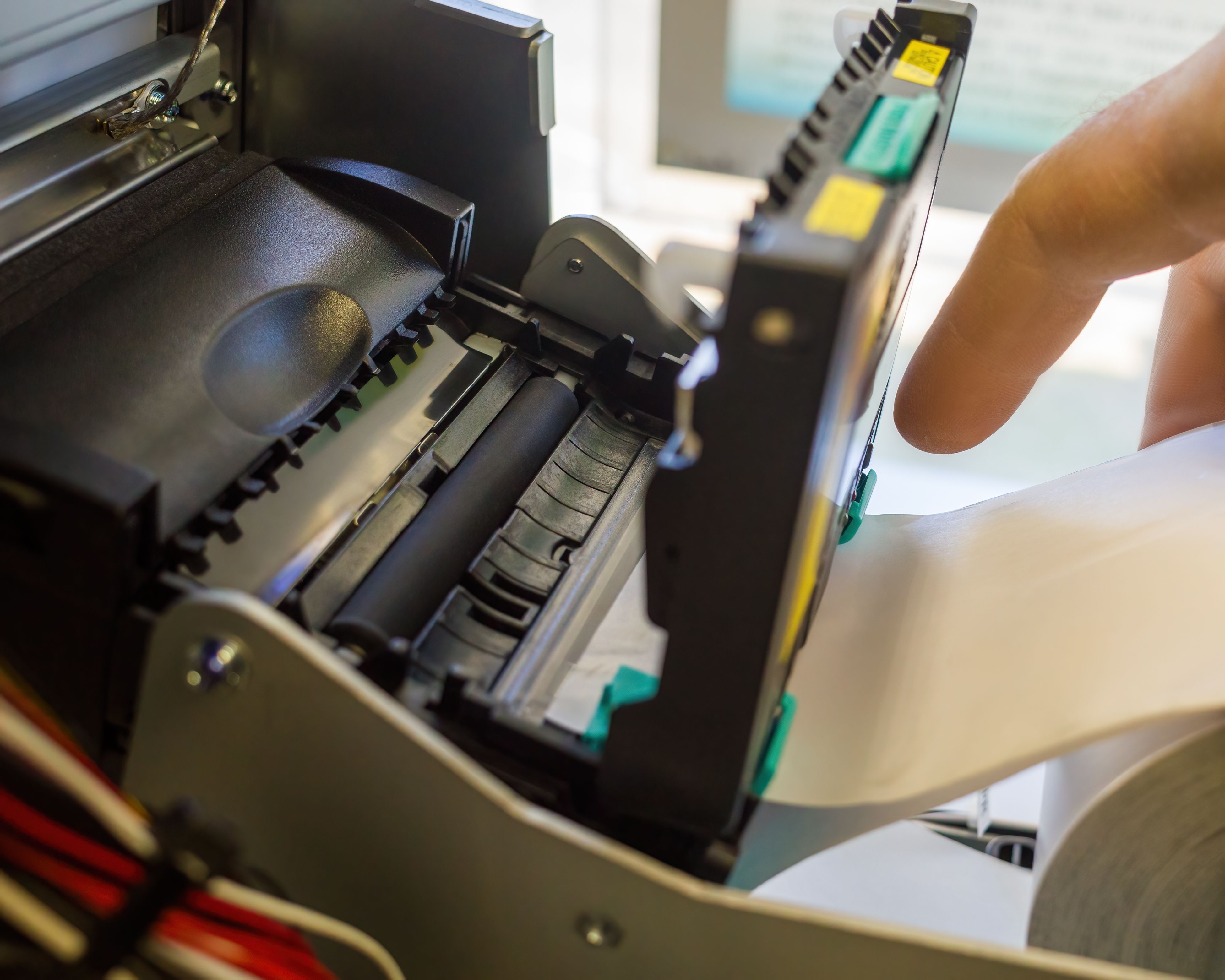 el ingeniero de servicio reemplaza la cinta térmica de papel en la impresora térmica de cheques del cajero automático