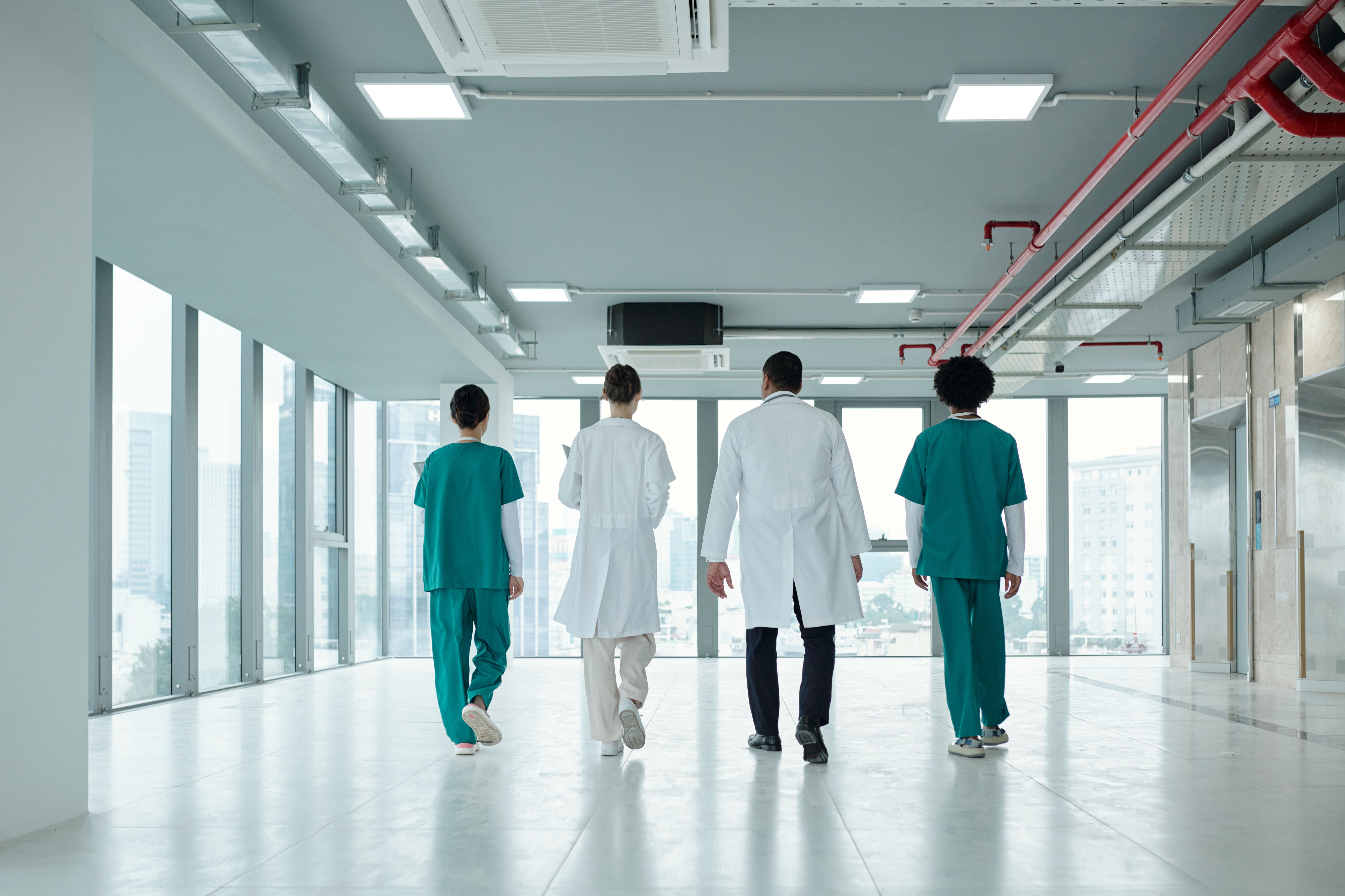 Colleagues Walking Along The Corridor In Hospital